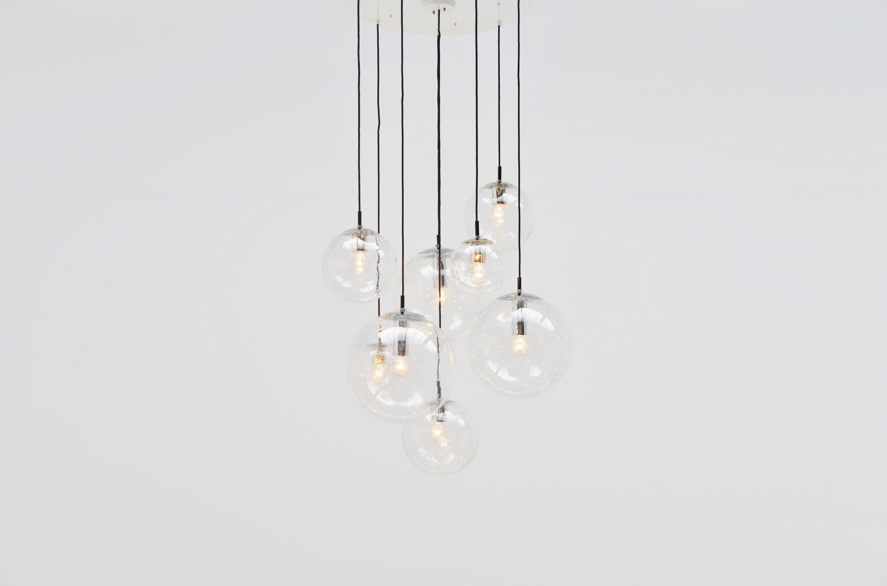 Huge raindrops chandelier designed and manufactured by RAAK Amsterdam, Holland, 1975. This chandelier has 3 different sizes of raindrop globes hanging on a large white metal ceiling plate. 3 Large ones, 3 medium ones and 2 small ones. This lamp was