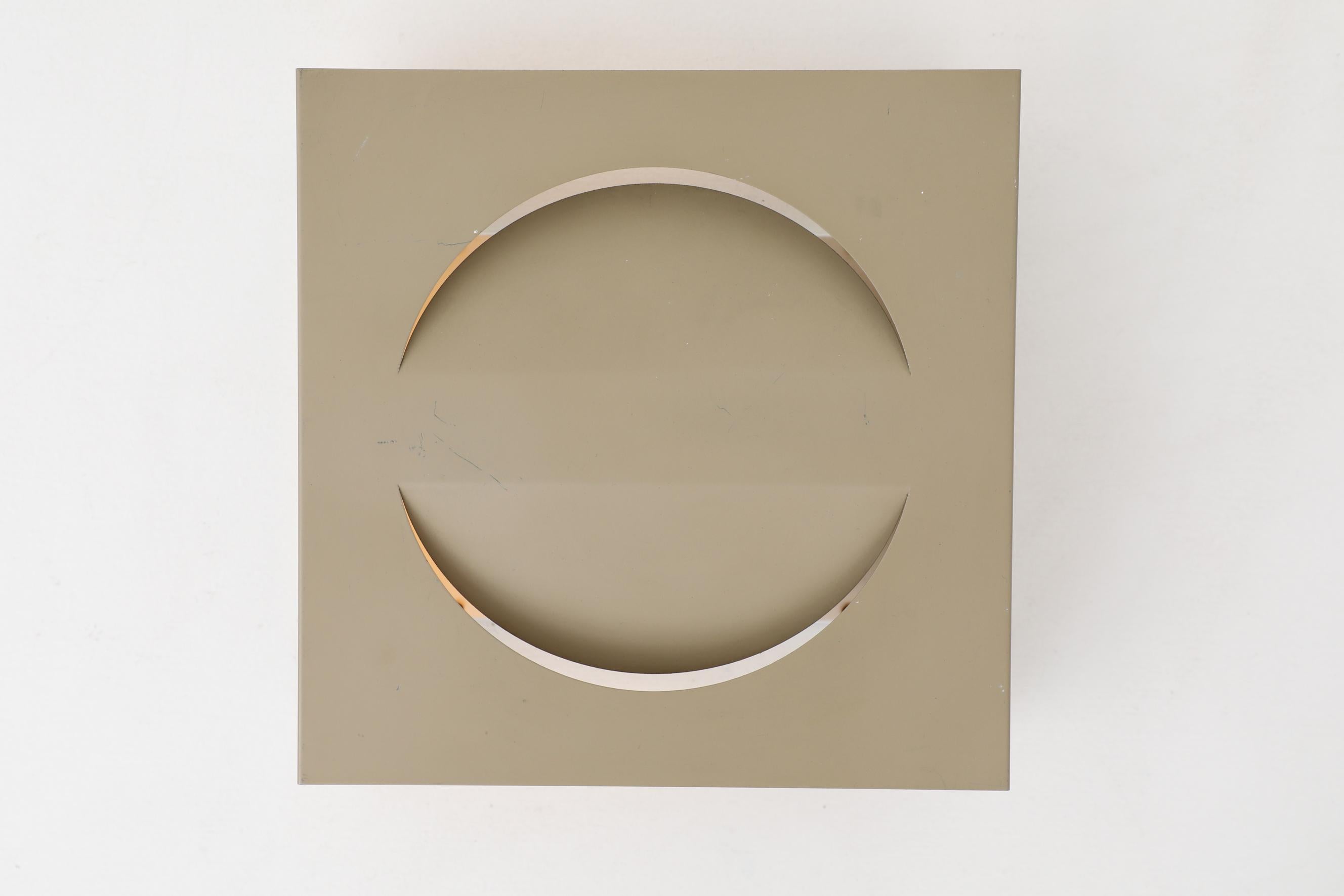 RAAK manufactured, square beige enameled metal sconce with half circle cut outs. Takes one bulb, not included. In original condition with visible wear, consistent with its age and use.