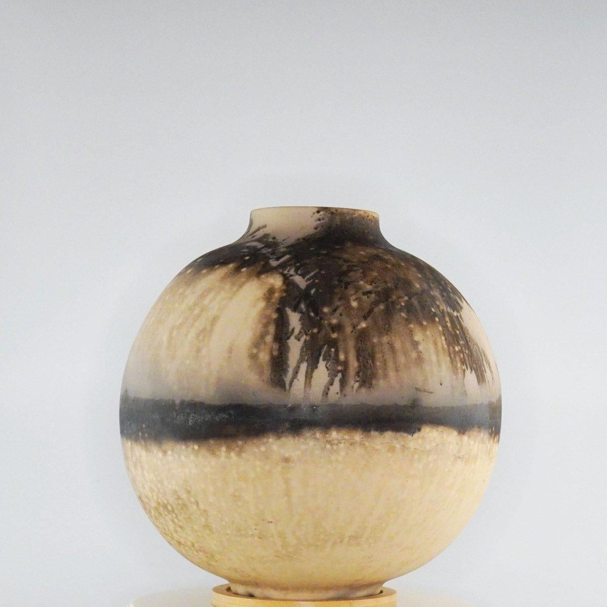 This Globe Vase is a round, capacious piece produced using the Raku technique, resulting in a beautiful unpredictable finish. This vase would be the perfect centerpiece or an addition to a growing collection of unique art in a home.

Obvara is a