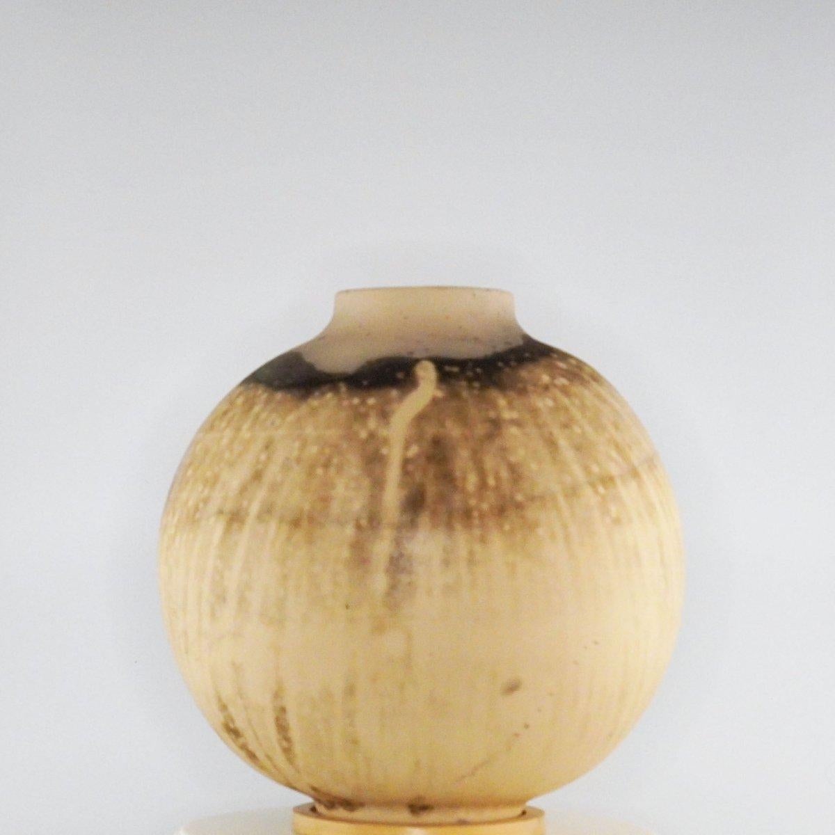 This globe vase is a round, capacious piece produced using the Raku technique, resulting in a beautiful unpredictable finish. This vase would be the perfect centerpiece or an addition to a growing collection of unique art in a home.

Obvara is a