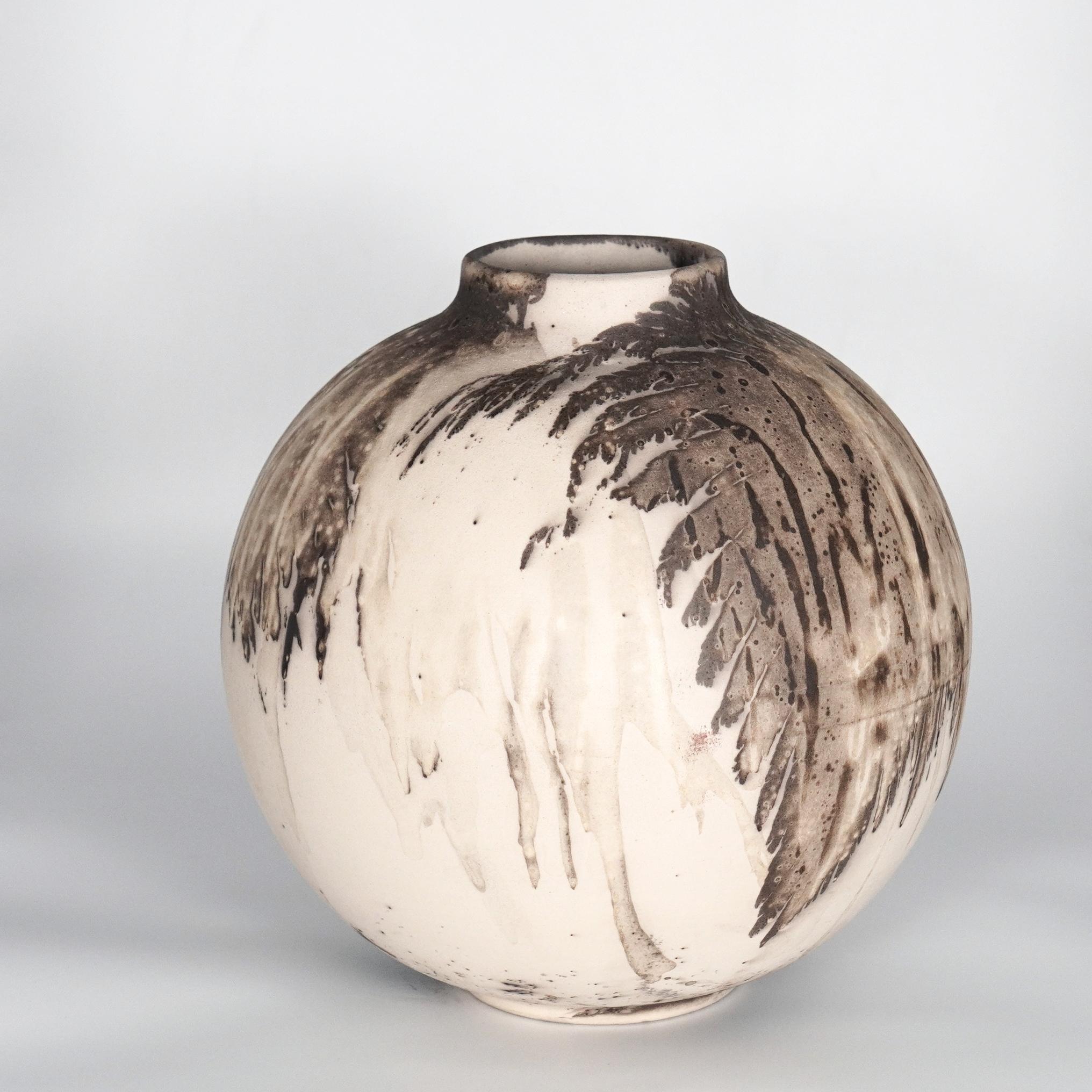This globe vase is a round, capacious piece produced using the Raku technique, resulting in a beautiful unpredictable finish. This vase would be the perfect centerpiece or an addition to a growing collection of unique art in a home.

Obvara is a