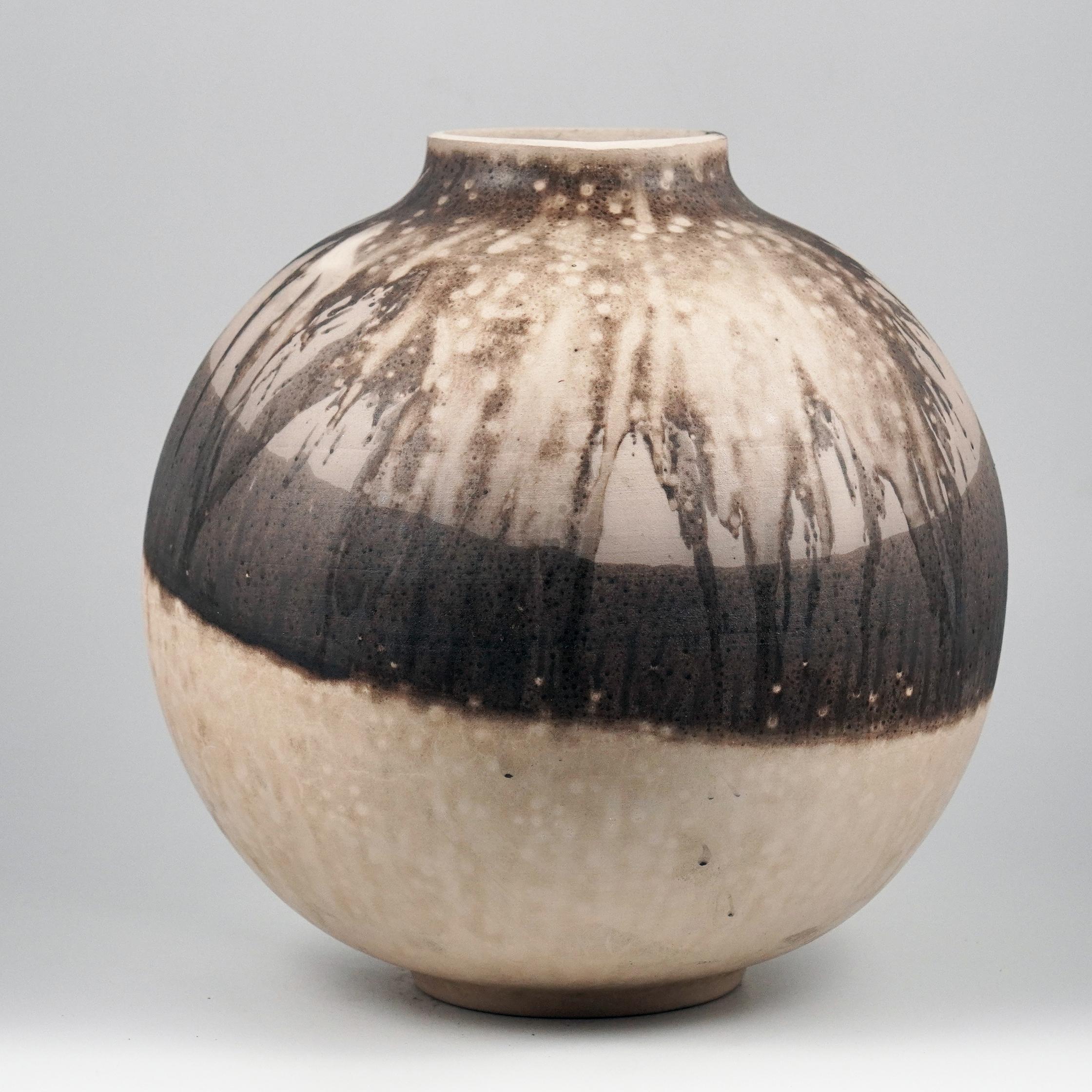 This globe vase is a round, capacious piece produced using the Raku technique, resulting in a beautiful unpredictable finish. This vase would be the perfect centerpiece or an addition to a growing collection of unique art in a home.

Obvara is a