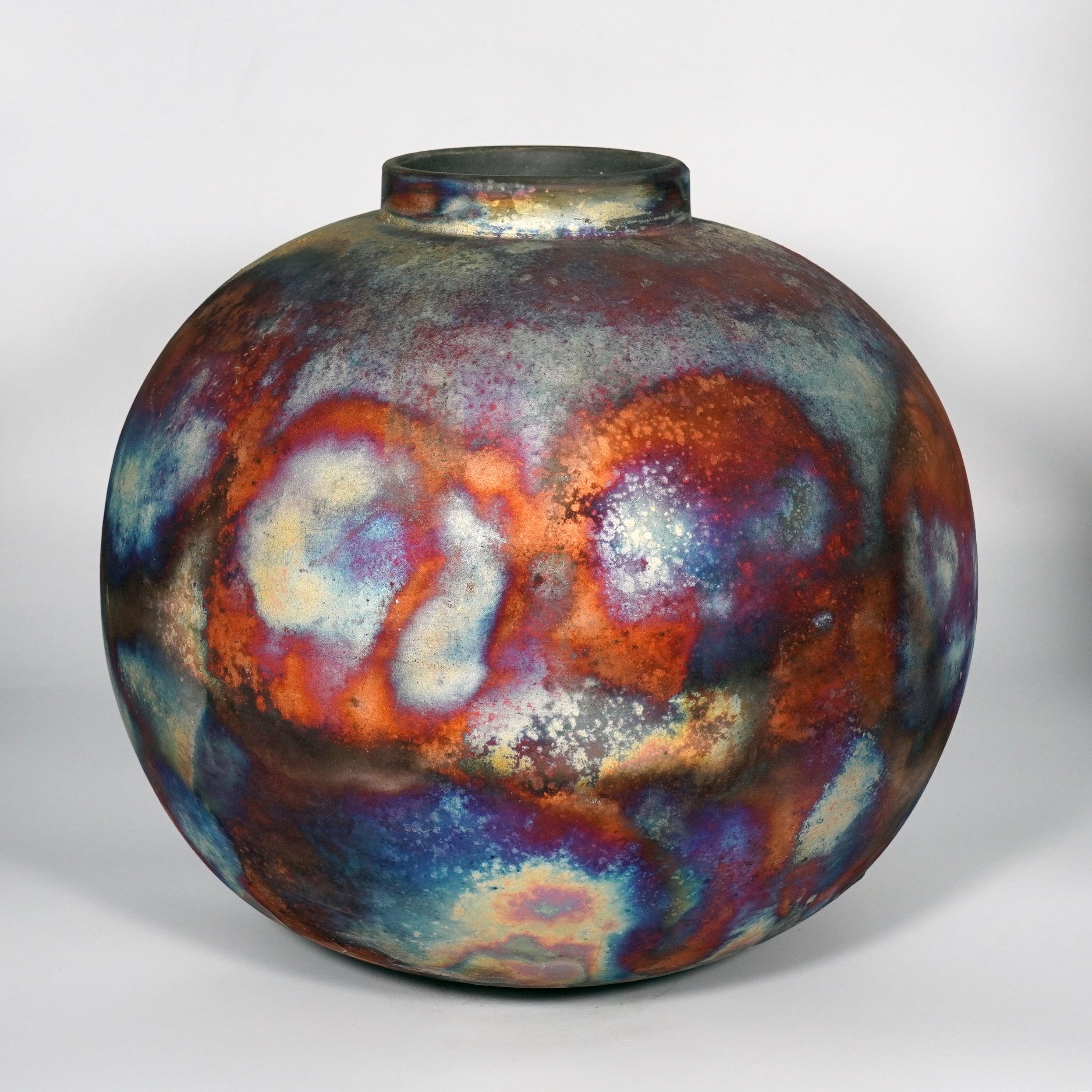 Uno spettacolo ipnotico da ammirare non appena le patine arcobaleno catturano la tua attenzione. Questo vaso Globe XL è un pezzo rotondo e capiente prodotto con la tecnica Raku, che dà luogo a una bellissima finitura imprevedibile. Questo vaso