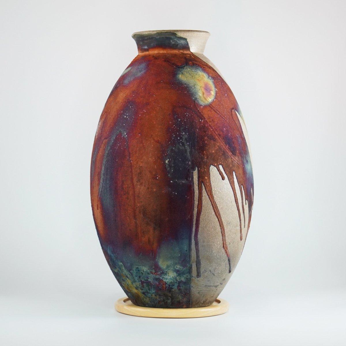 A mesmerizing sight to behold as soon as the rainbow-like patinas catch your eye. The Oval Vase is a tall, teardrop-shaped design best for adding a touch of elegance and intrigue to an interior space. Made using the Raku technique, it easily becomes