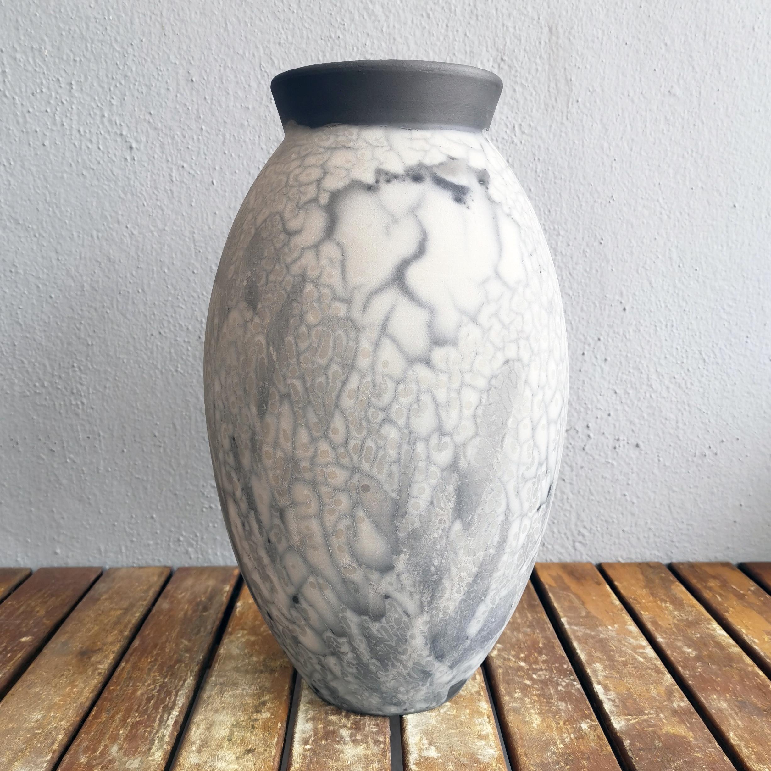 The Oval Vase is a tall, teardrop-shaped design best for adding a touch of elegance and intrigue to an interior space. Made using the Raku technique, it easily becomes a great conversation starter.

Smoked Raku is more commonly known as 'Naked'