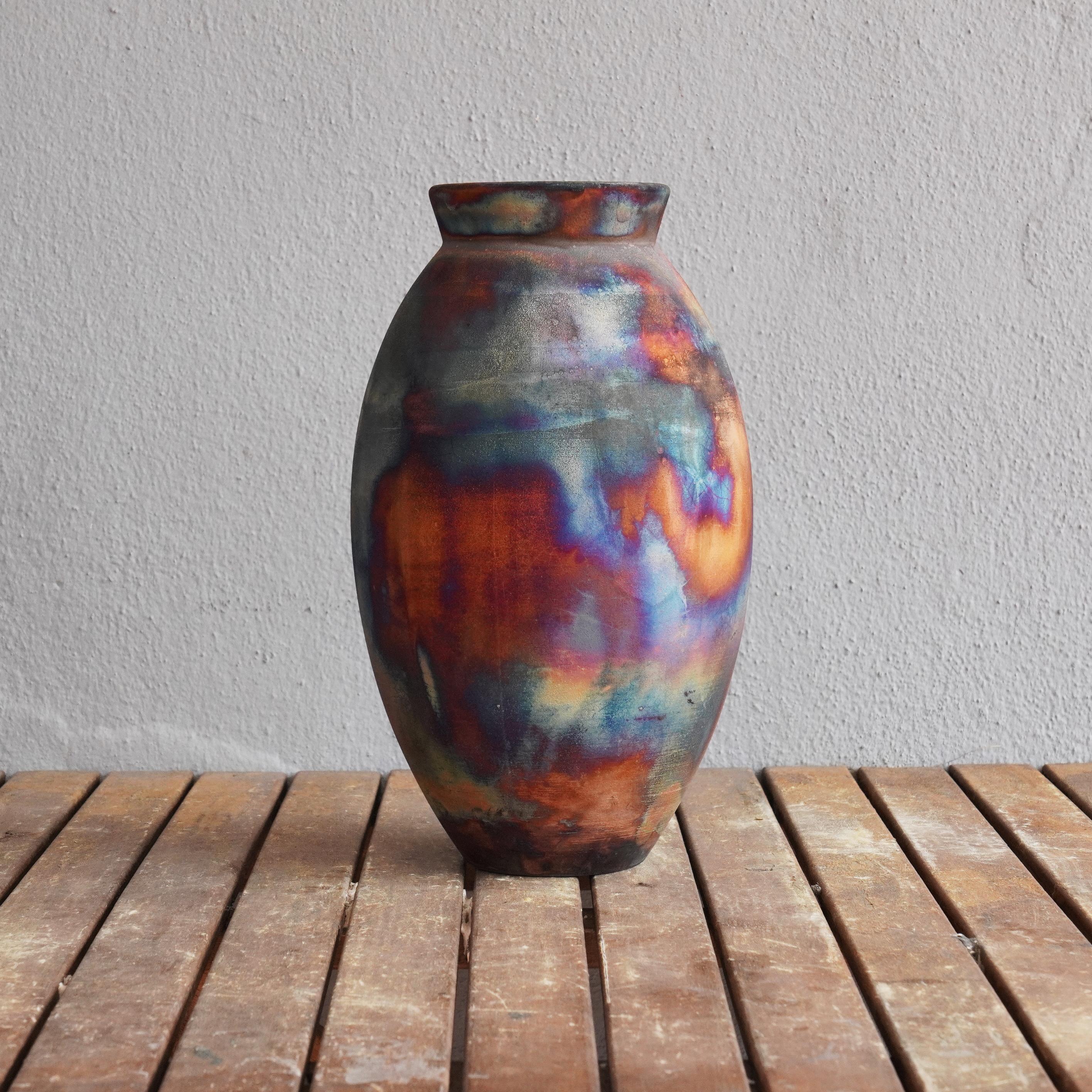 The Large Oval Raku fired vase centerpiece Series by RAAQUU.

A mesmerizing sight to behold as soon as the rainbow-like patinas catch your eye. The Oval Vase is a tall, teardrop-shaped design best for adding a touch of elegance and intrigue to an