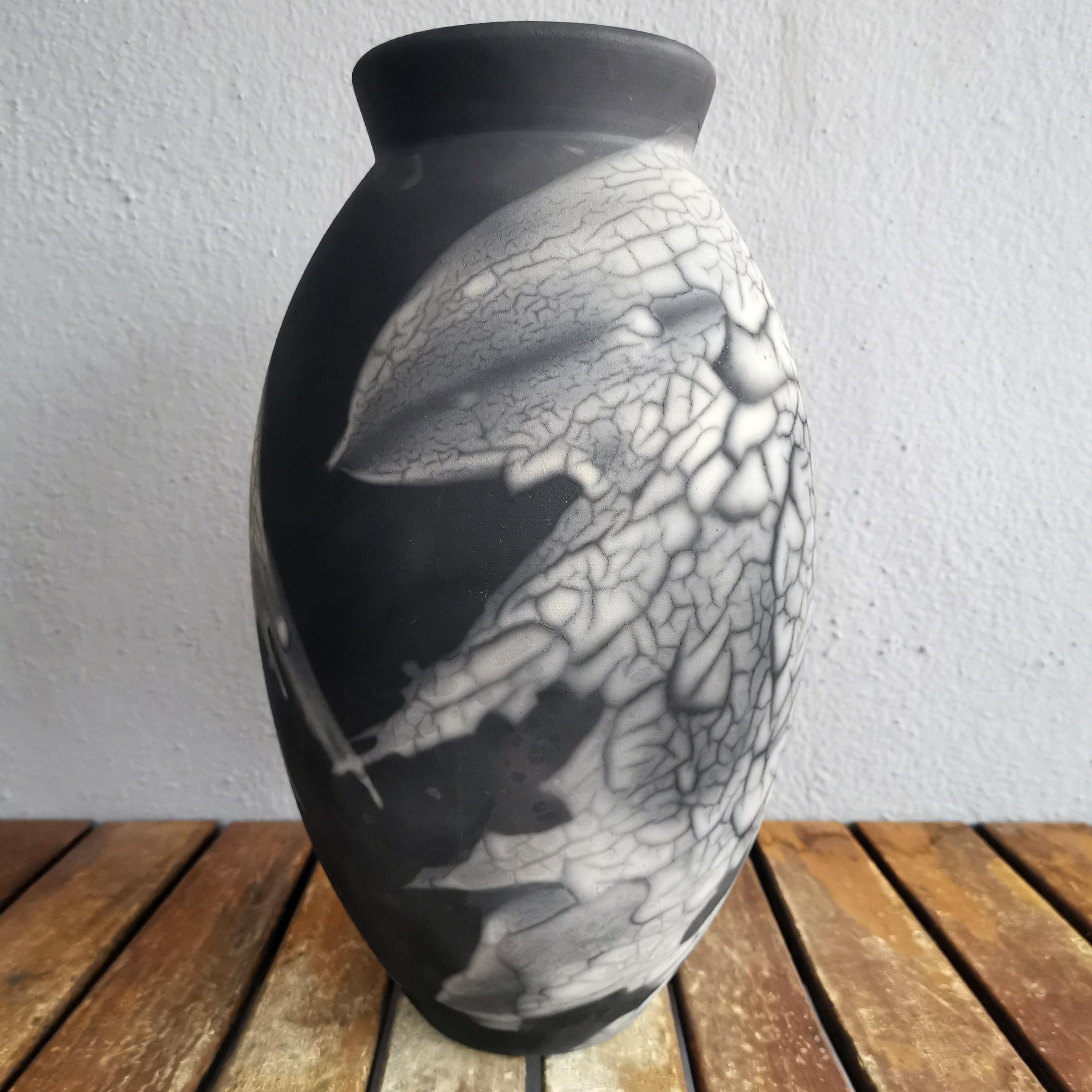 El Jarrón ovalado es un diseño alto, en forma de lágrima, ideal para añadir un toque de elegancia e intriga a un espacio interior. Fabricado con la técnica Raku, se convierte fácilmente en un gran tema de conversación.
 
El rakú ahumado se conoce