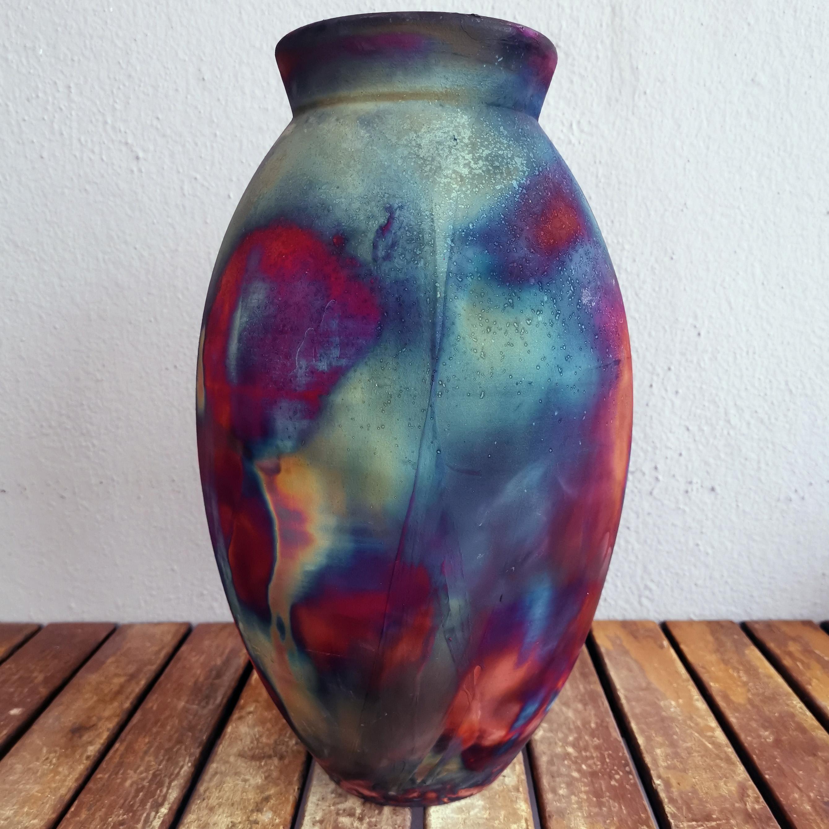 A mesmerizing sight to behold as soon as the rainbow-like patinas catch your eye. The Oval Vase is a tall, teardrop-shaped design best for adding a touch of elegance and intrigue to an interior space. Made using the Raku technique, it easily becomes