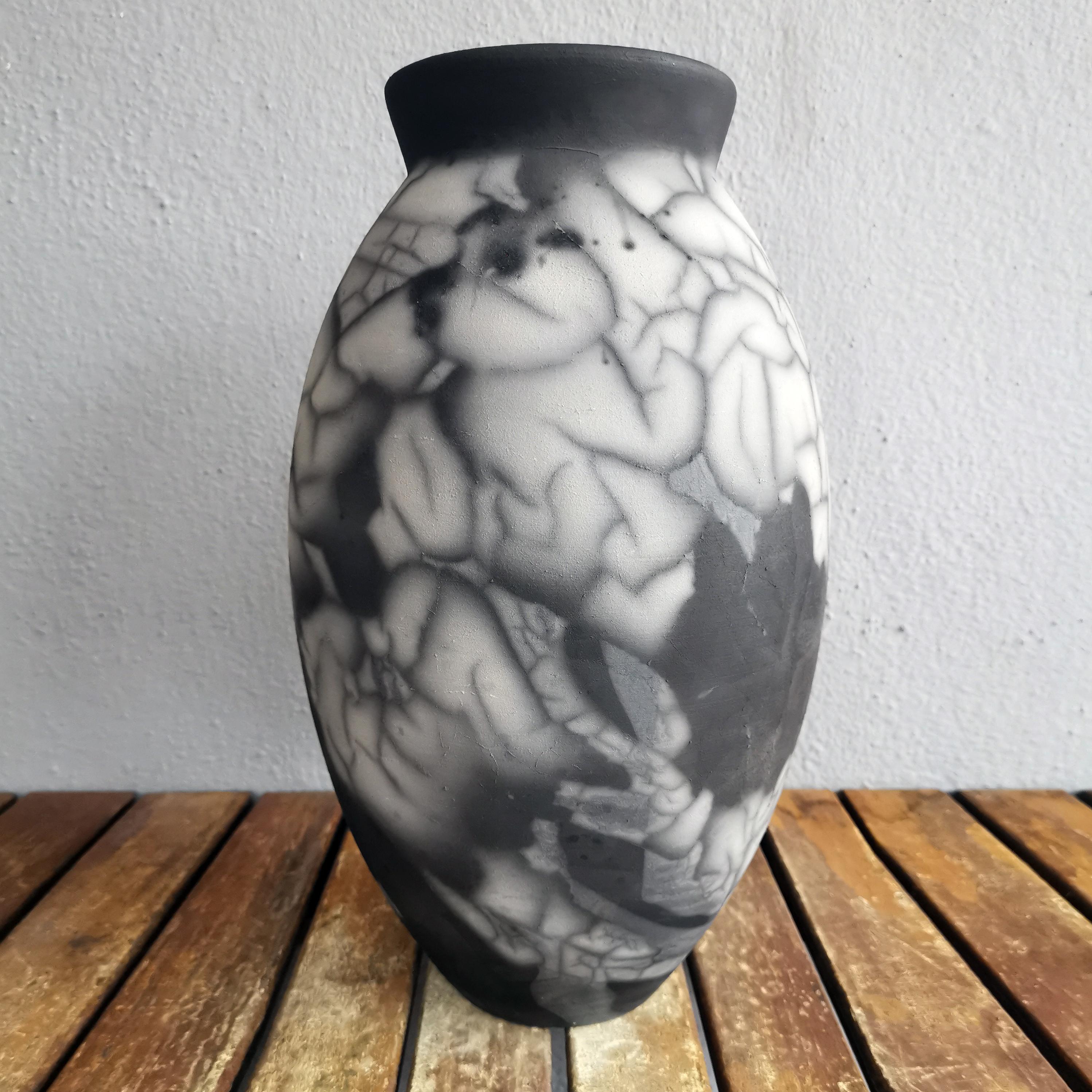The Oval Vase is a tall, teardrop-shaped design best for adding a touch of elegance and intrigue to an interior space. Made using the Raku technique, it easily becomes a great conversation starter.
 
Smoked Raku is more commonly known as 'Naked'