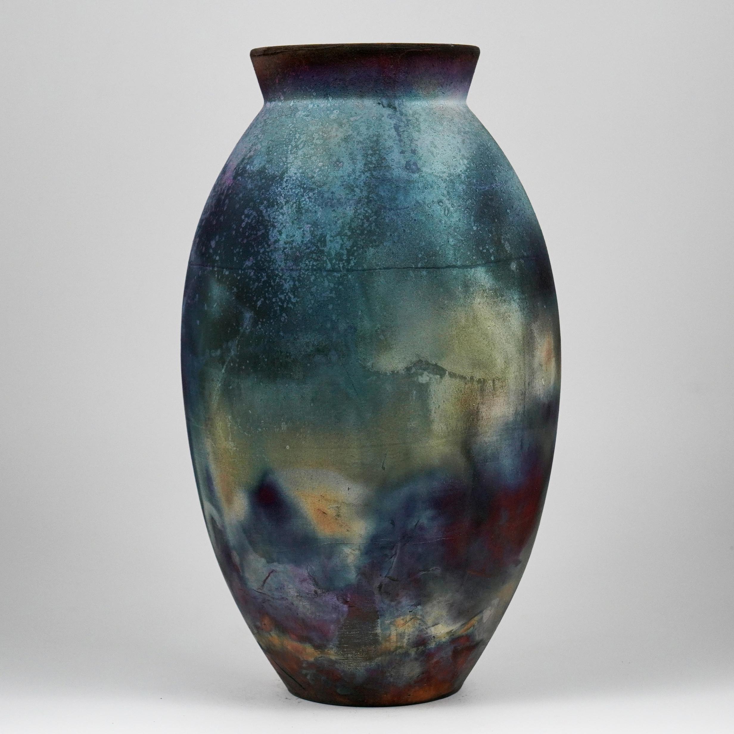 A mesmerizing sight to behold as soon as the rainbow-like patinas catch your eye. The Oval Vase is a tall, teardrop-shaped design best for adding a touch of elegance and intrigue to an interior space. Made using the Raku technique, it easily becomes