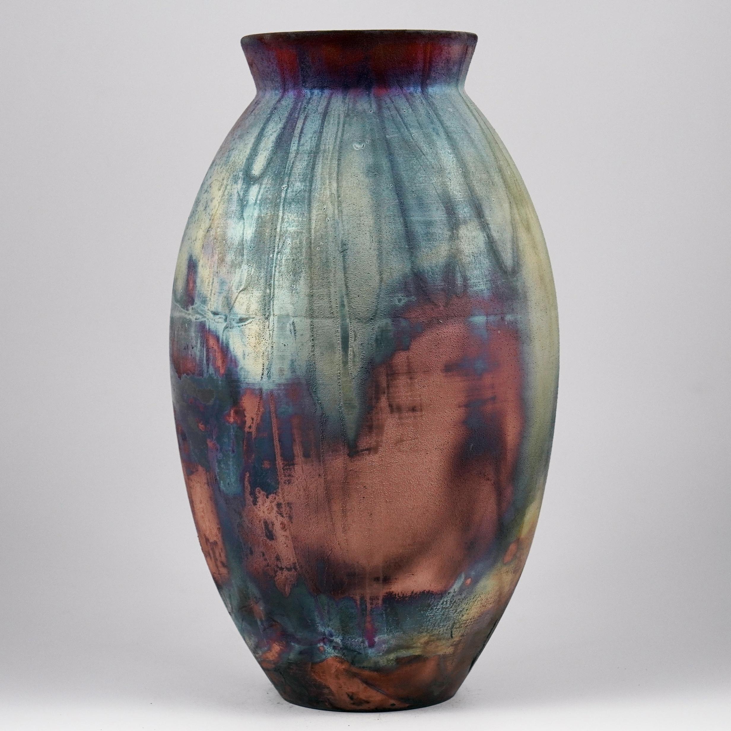 A mesmerizing sight to behold as soon as the rainbow-like patinas catch your eye. The Oval Vase is a tall, teardrop-shaped design best for adding a touch of elegance and intrigue to an interior space. Made using the Raku technique, it easily becomes