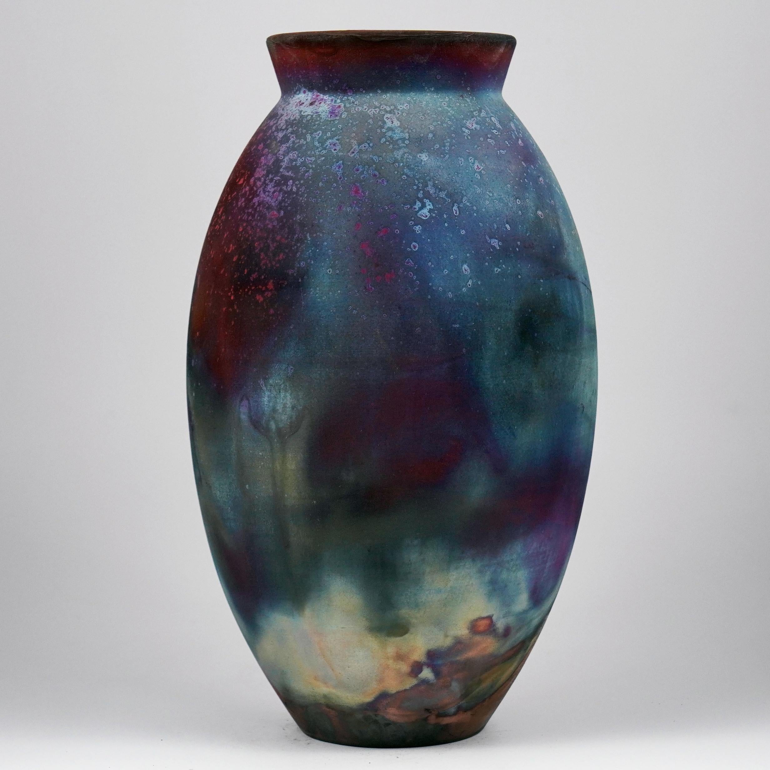 A mesmerizing sight to behold as soon as the rainbow-like patinas catch your eye. The Oval Vase is a tall, teardrop-shaped design best for adding a touch of elegance and intrigue to an interior space. Made using the Raku technique, it easily becomes