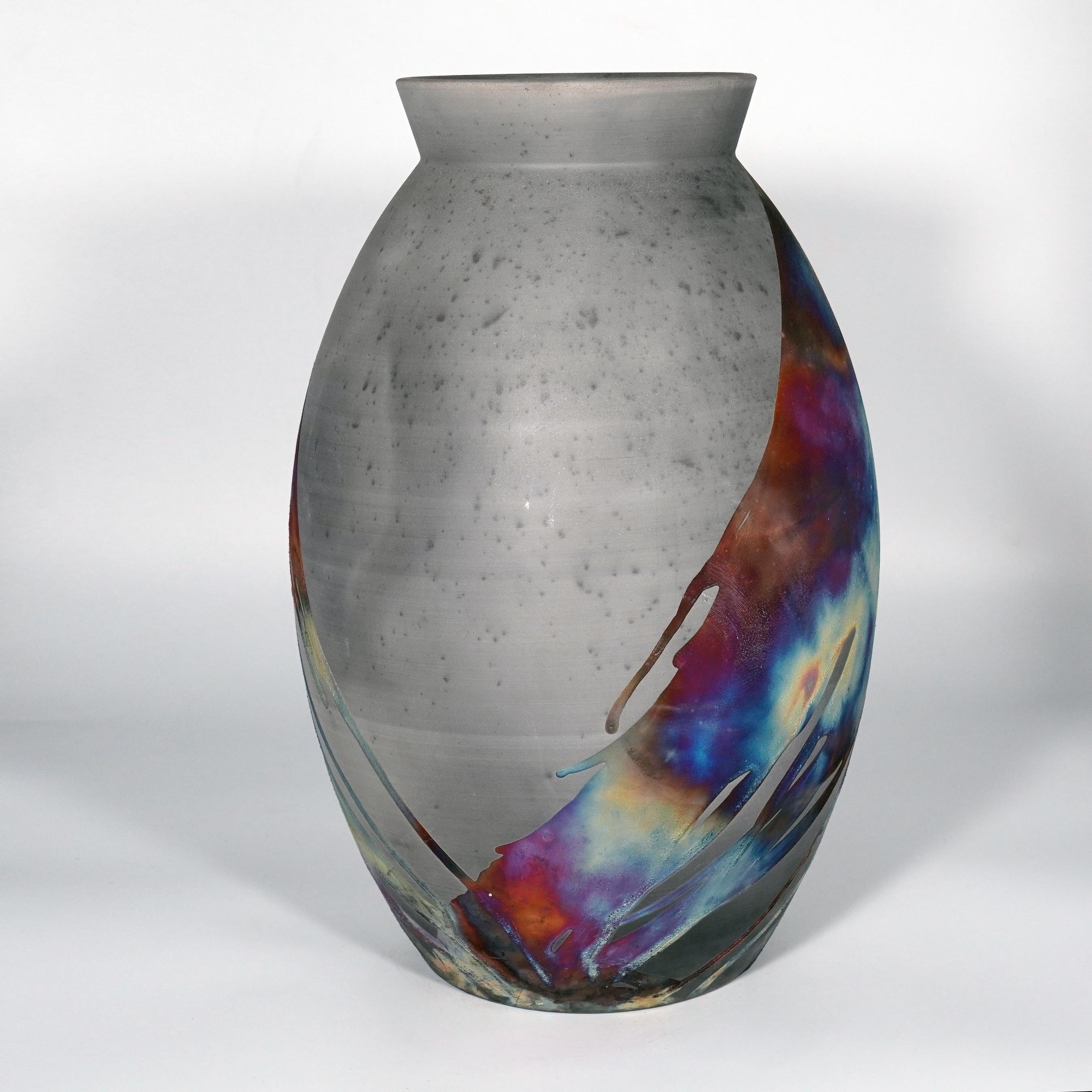 A mesmerizing sight to behold as soon as the rainbow-like patinas catch your eye. The Oval XL Vase is a tall, teardrop-shaped design best for adding a touch of elegance and intrigue to an interior space. Made using the Raku technique, it easily
