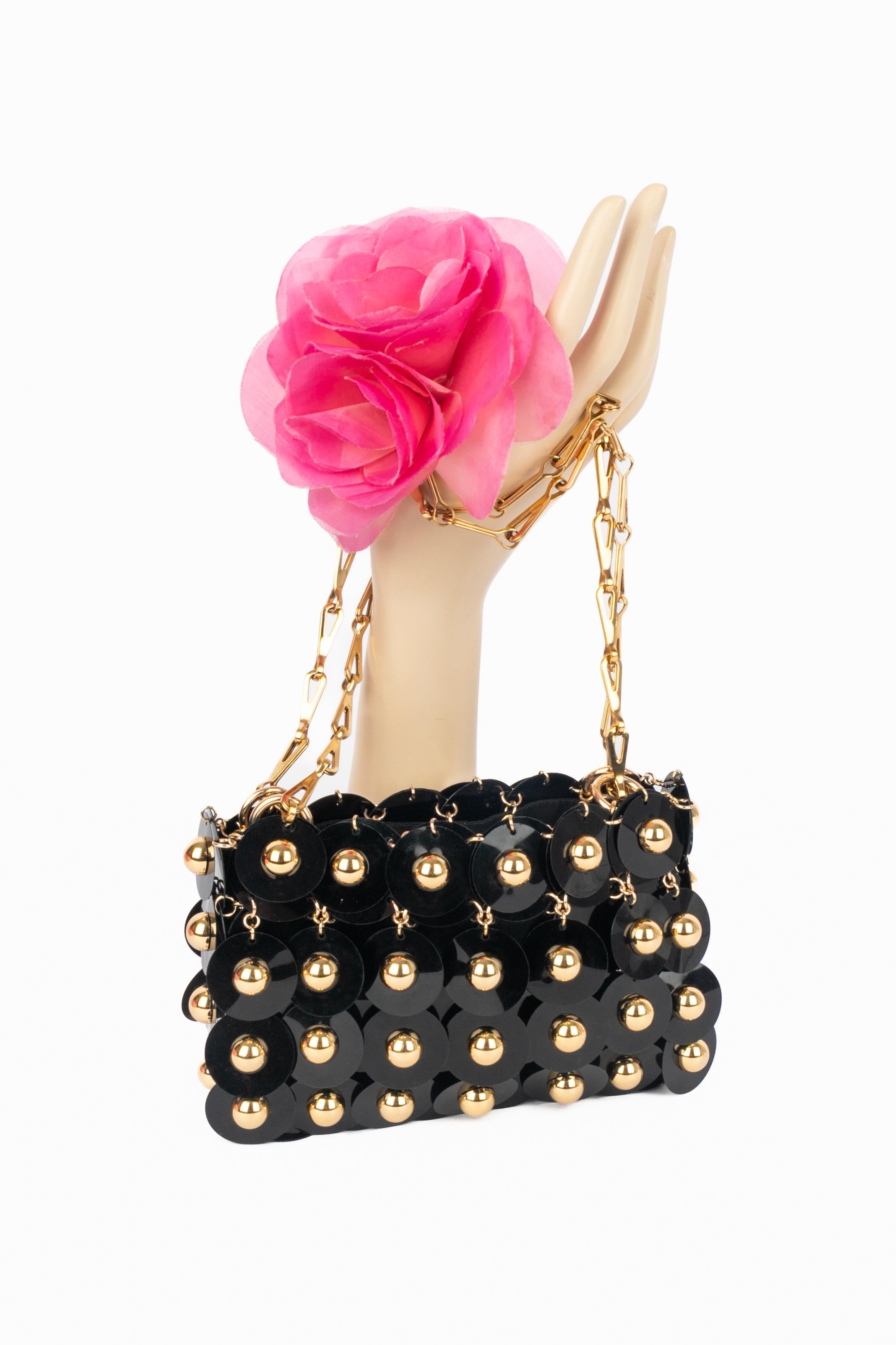 PACO RABANNE - Sac en pastilles de rhodoïd noir et clous métalliques dorés. Réinterprétation du design iconique '1969', ce sac a été créé dans les années 2020 sous la direction artistique de Julien Dossena.

Condit :
Très bon état.

Dimensions