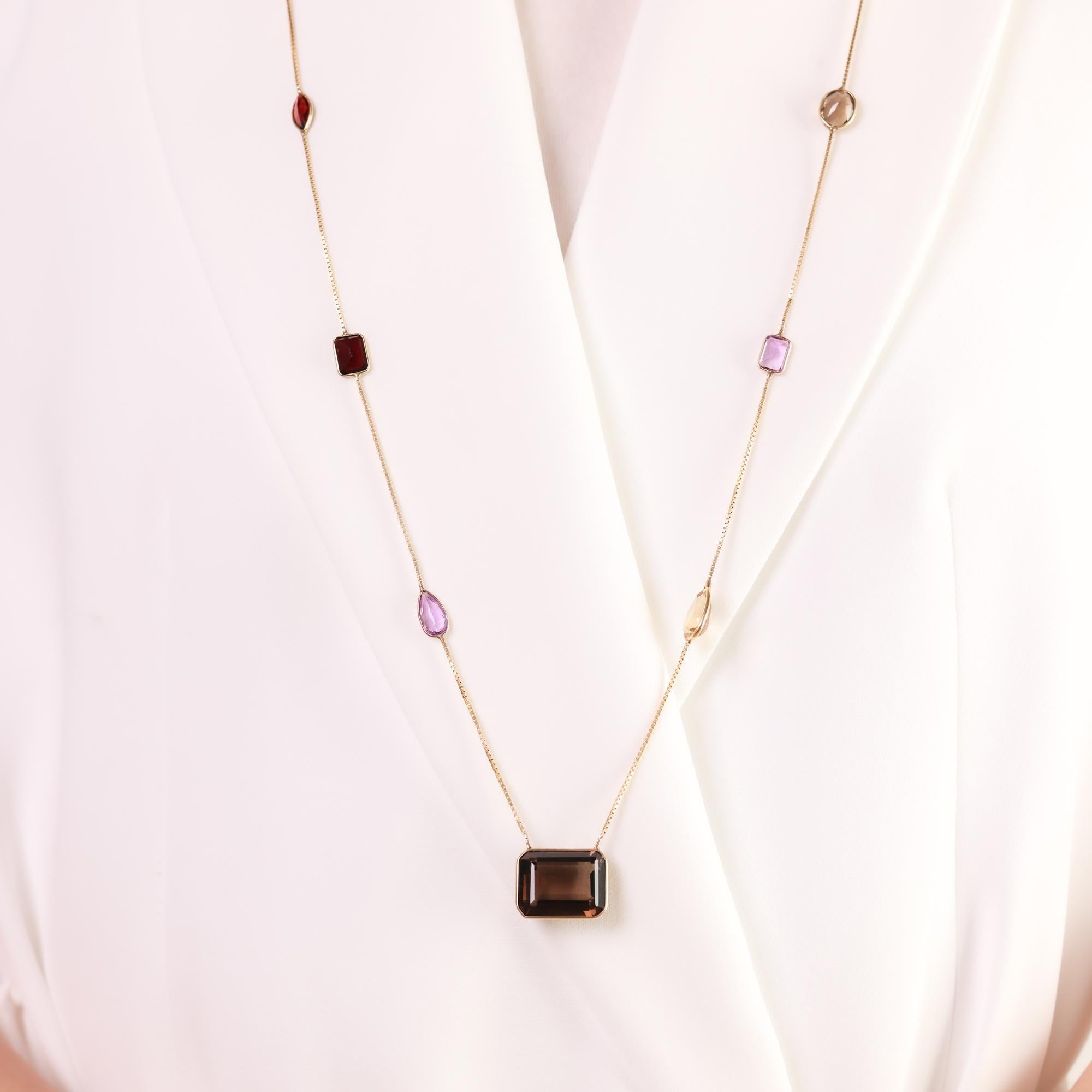 This vintage Rabbani necklace showcases a striking 18-carat smoky quartz complemented by a colorful array of amethysts, rubellites, citrines, and quartzes, set in 14k yellow gold.

Brand: Rabbani
Total gemstone weight: Approximately 33.20