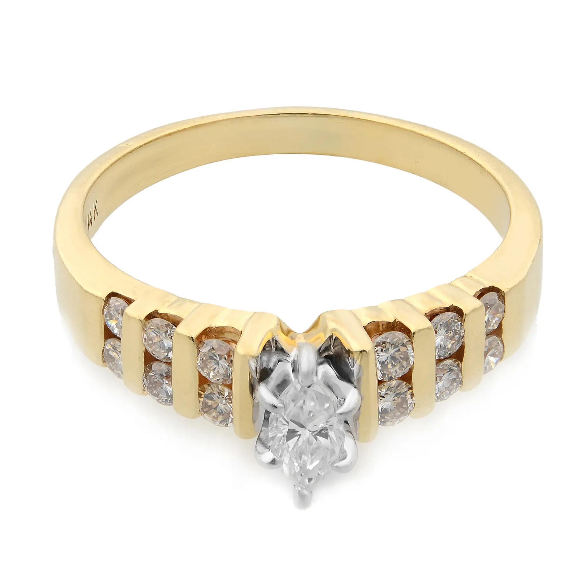 Cette magnifique et séduisante bague de fiançailles présente un diamant central de forme marquise serti sur un anneau, flanqué de diamants ronds sertis en canal sur les épaules de l'anneau pour ajouter à la beauté de l'ensemble. Fabriqué en or jaune