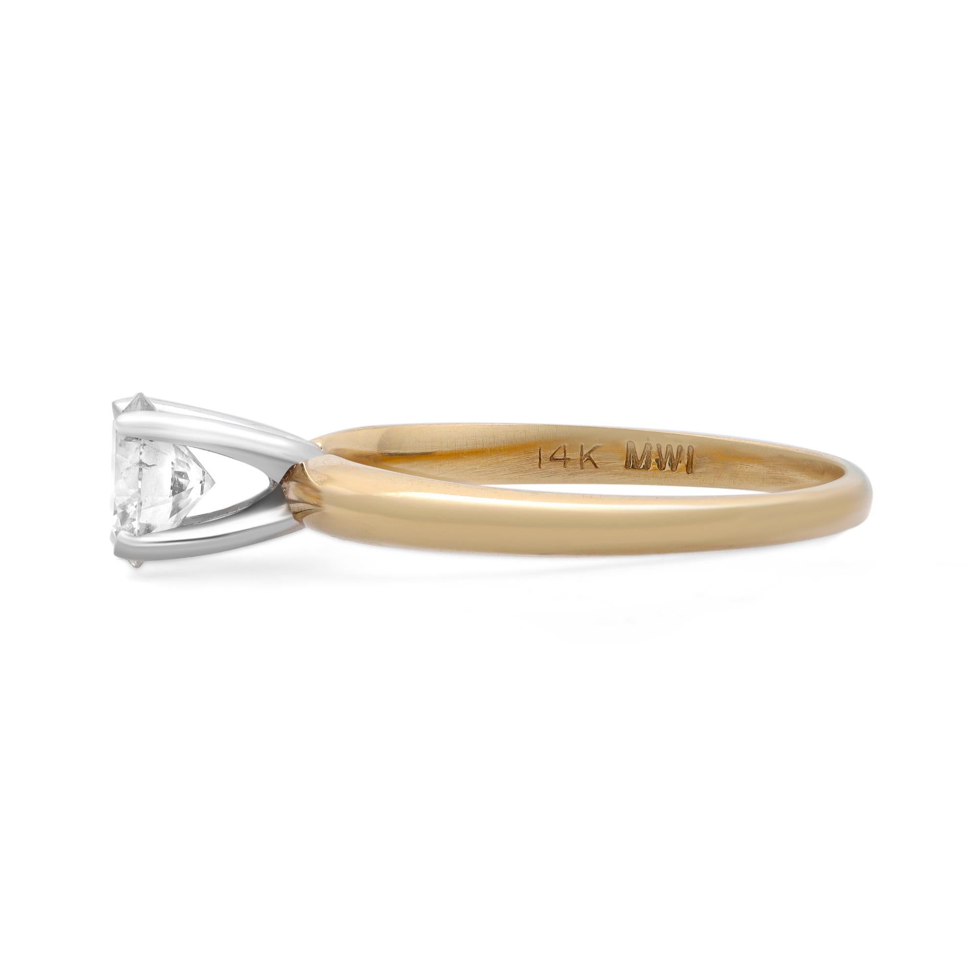 This stunning round shaped diamond engagement ring sits a little high and gives the appearance of being a larger carat weight than it actually is. Crafted in 14K yellow gold with white gold prongs, this ring features a classic four prong set round