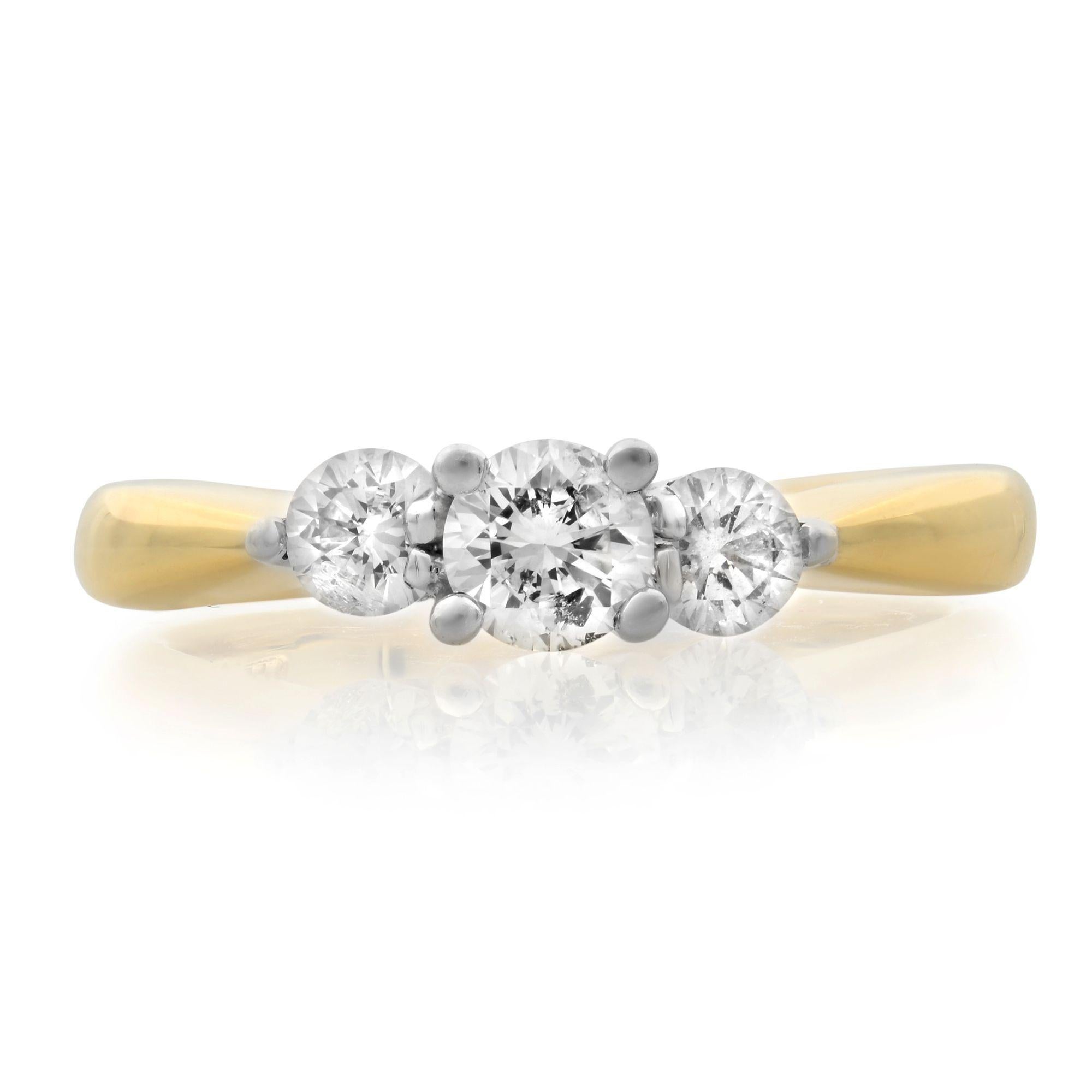 This elegant three-stone engagement ring features a round cut diamond center stone set in 14K white gold with sparkling round diamonds on either side. The 14K yellow gold band complements the design, and the ring has a total diamond weight of 0.40