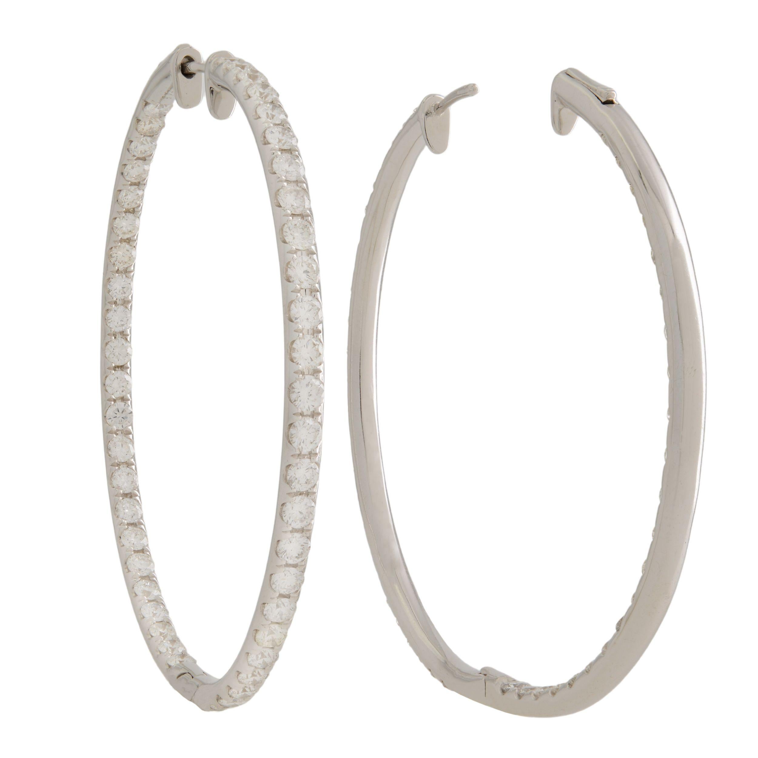 A very beautiful pair of Estate inside-out diamond medium hoop earrings. Each earring is crafted in 18K white gold which are lined with sparkling round cut pave set diamonds. The stones line only half of the outer hoop and half of the inner hoop.