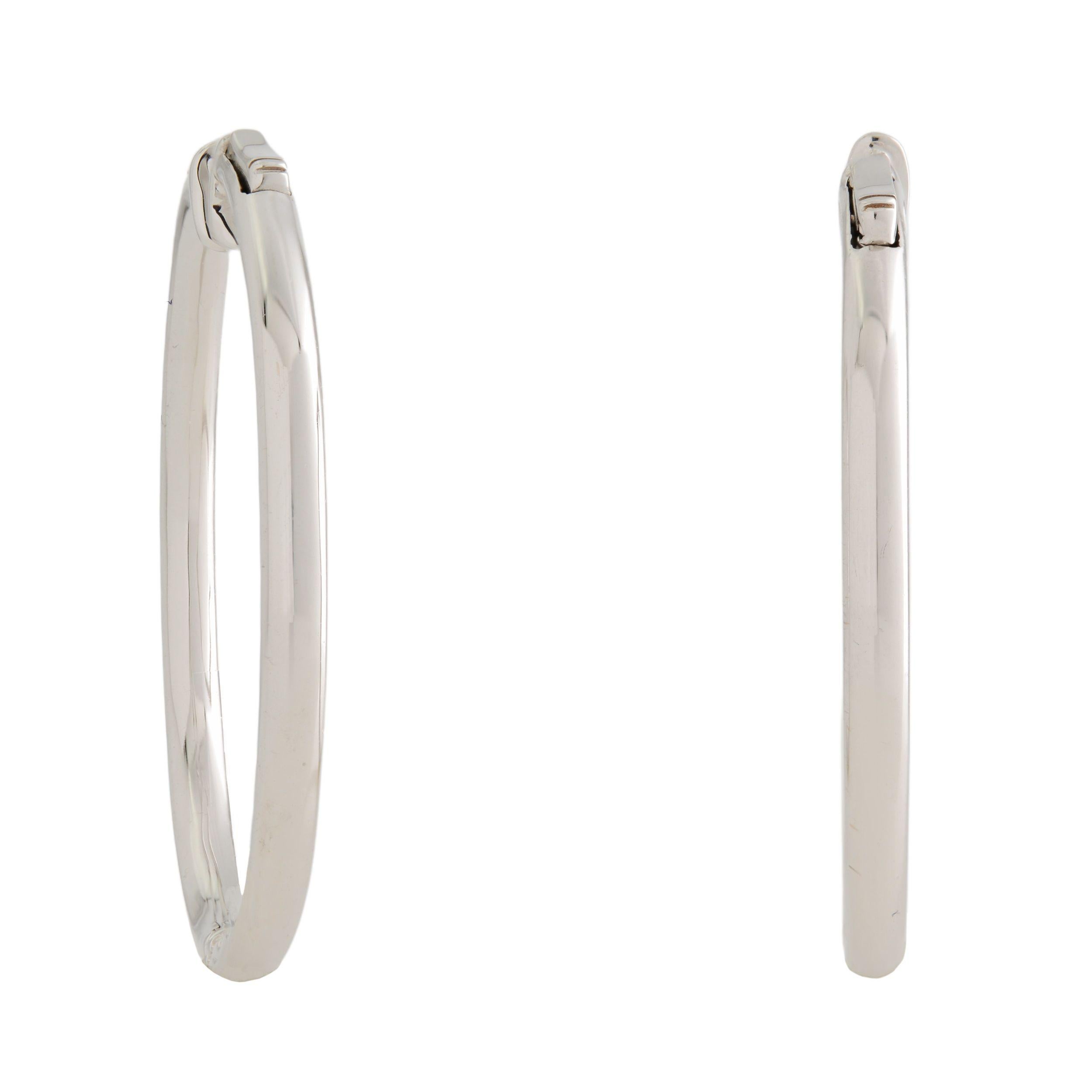 A very beautiful pair of Estate inside-out diamond small hoop earrings. Each earring is crafted in 18K white gold which are lined with sparkling round cut pave set diamonds. The stones line only half of the outer hoop and half of the inner hoop.