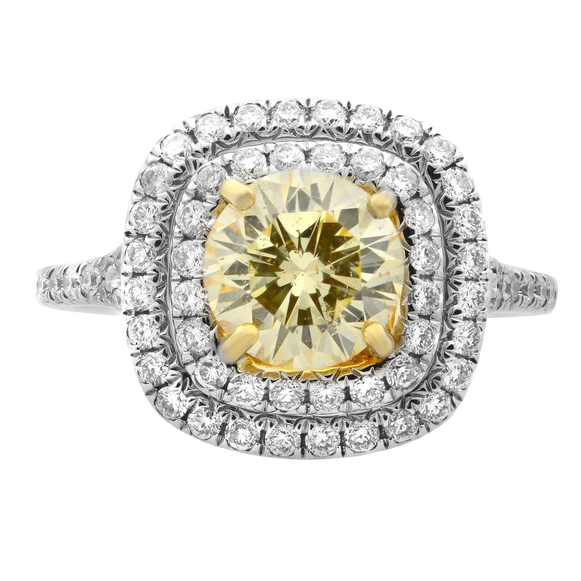 A cushion diamond double halo ring with a light fancy yellow round cut center stone, certified by GIA, center stone weighting 1.13 carat. Side diamonds weighting 0.55 carat. The ring is mounted in 18K white and yellow gold, with collection color