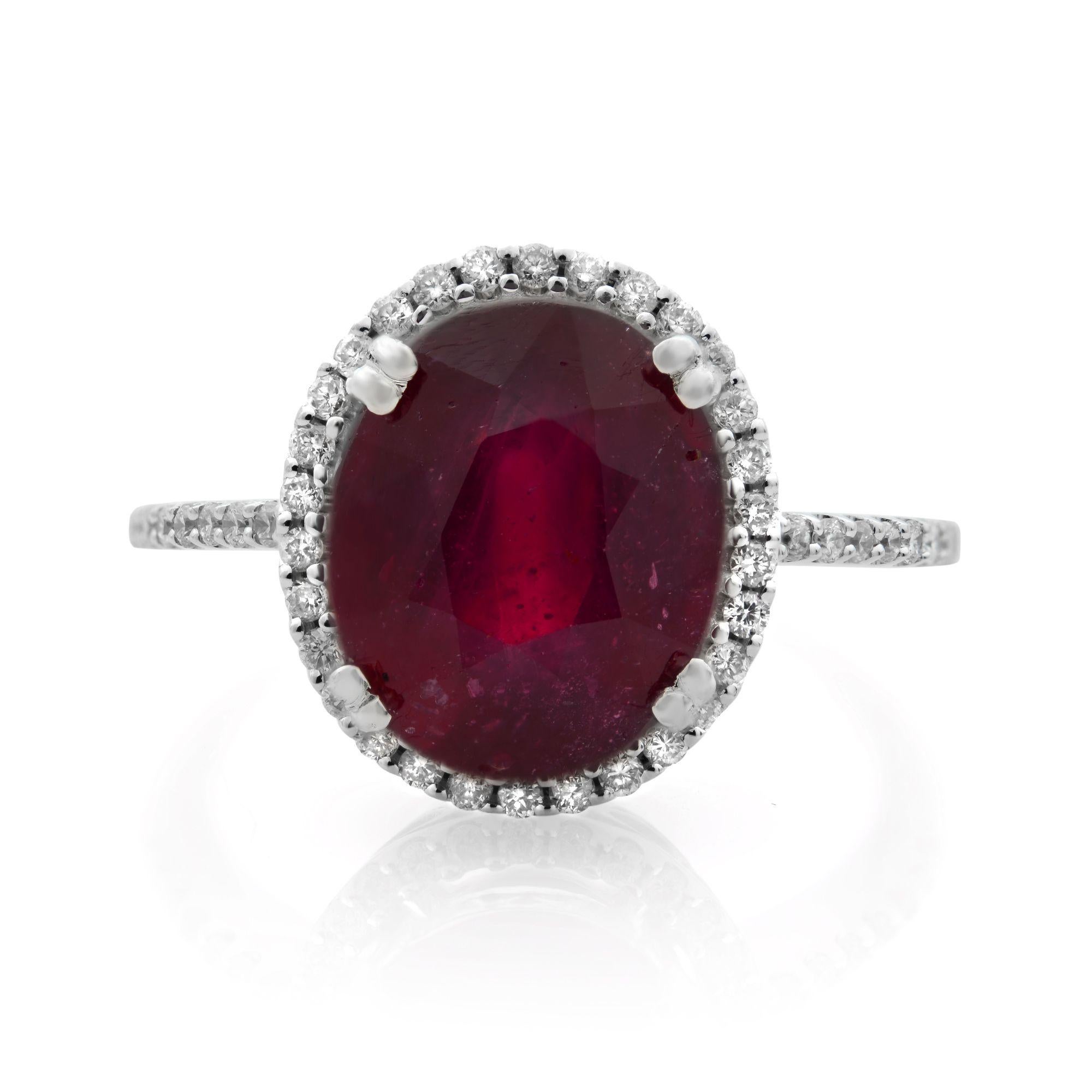 The beautiful 3.60 carat ruby catches attention with its bold red hue. Brilliant diamonds of 0.22 carat form a halo around the oval gem and adorn the shank of this timeless 14k white gold engagement ring. Diamond color G and SI2 clarity. Ring size
