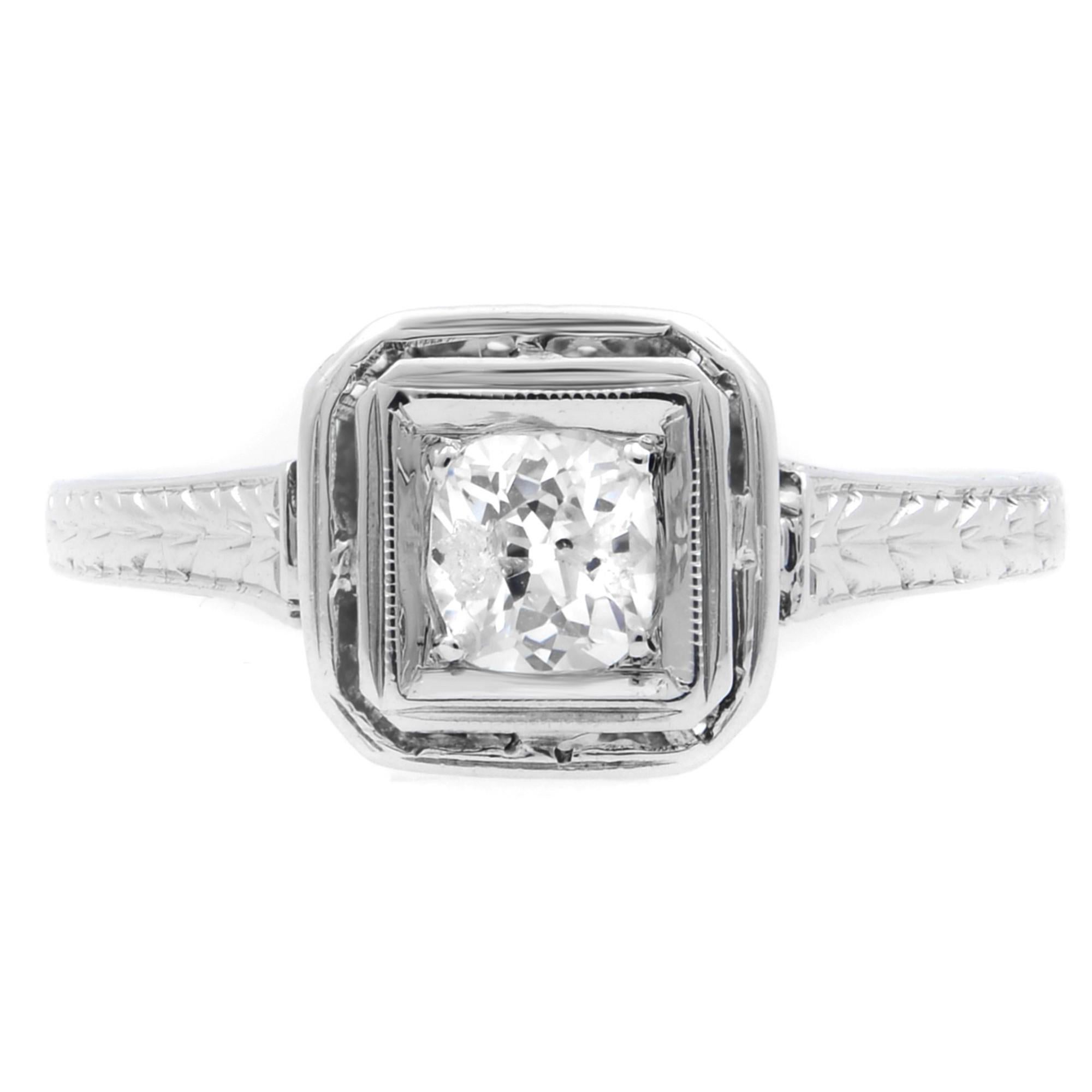Simple yet alluring, this antique diamond engagement ring is crafted in platinum. It features a prong set round cut diamond weighing 0.50 carat with an engraved shank. Diamond quality: color G-H and clarity SI2. Ring size: 6. Total weight: 2.21