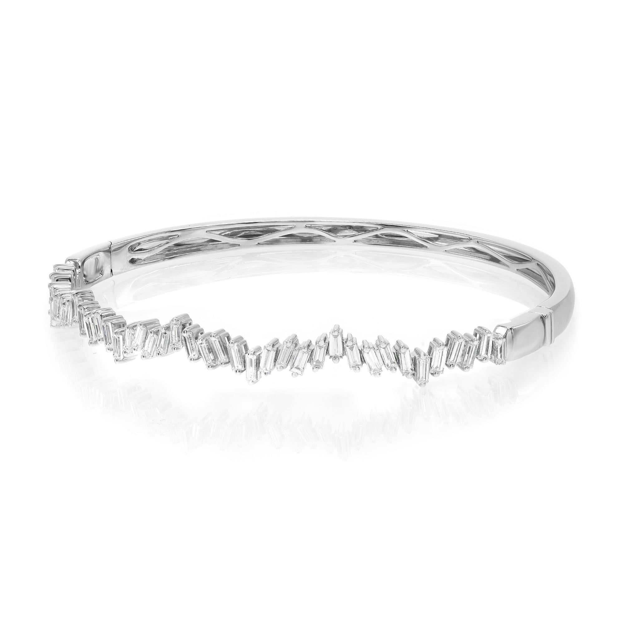 A classic look with easy elegance, this diamond bangle bracelet exudes sophistication. Crafted in 18k white gold. This bangle features baguette cut diamonds encrusted halfway through the bangle in a zig-zag pattern in prong setting with a total