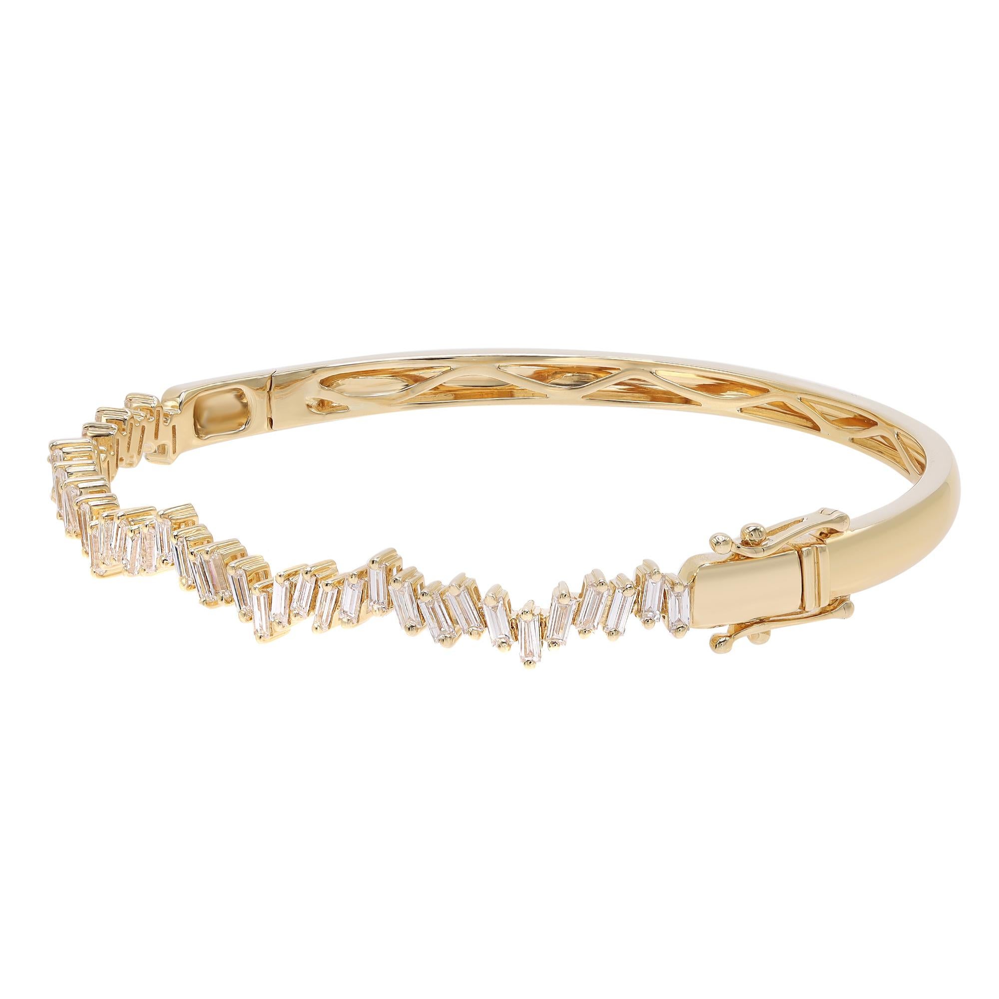 A classic look with easy elegance, this diamond bangle bracelet exudes sophistication. Crafted in 18k yellow gold. This bangle features baguette cut diamonds encrusted halfway through the bangle in a zig-zag pattern in prong setting with a total