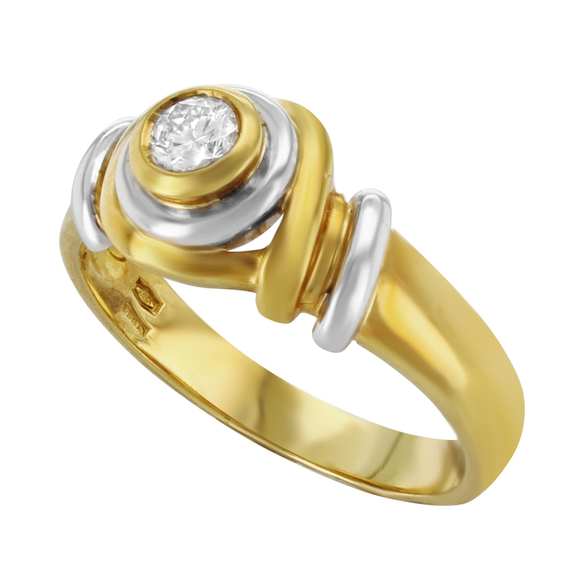 This contemporary ring is made of 18k yellow gold set with 0.20 cts diamond in bezel setting. The ring has white gold accents, which provides a very sophisticated style. Total ring weight: 5.5 grams. Ring size 8. The ring is available to be resized,