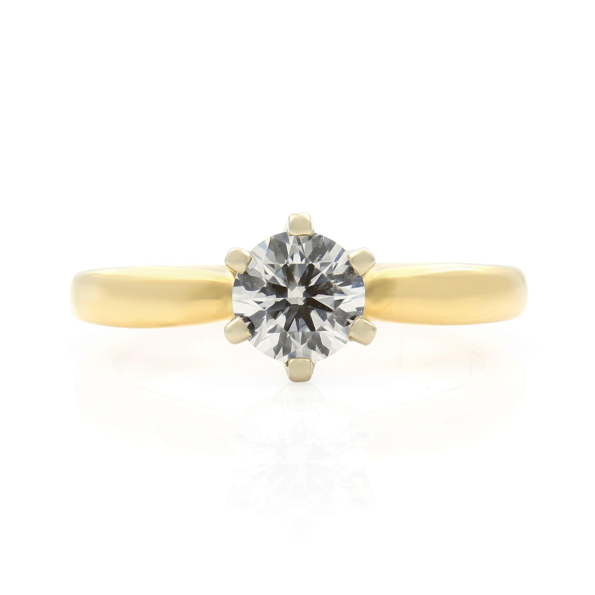 This classic solitaire engagement ring is crafted in 14K yellow gold and features a prong set round brilliant cut diamond weighing 0.70cts. Diamond quality: color F and clarity VS2. The high polished finish of this solitaire ring exemplifies the