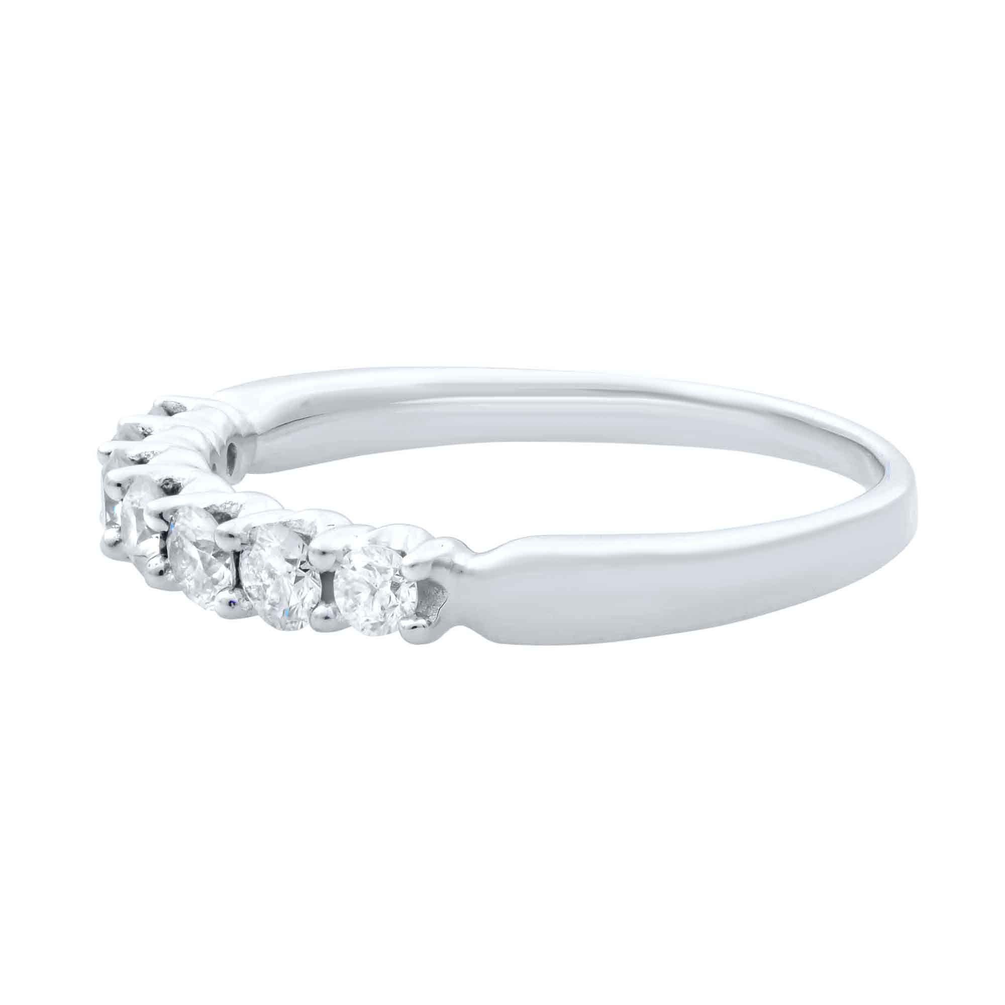 A seven sparkling round diamonds ring, secured in a four prong setting on a 14k white gold band. Exhibiting a half eternity design, this timeless wedding band symbolizes eternal love. The total diamond carat weight is 0.42ct. Diamonds are SI1