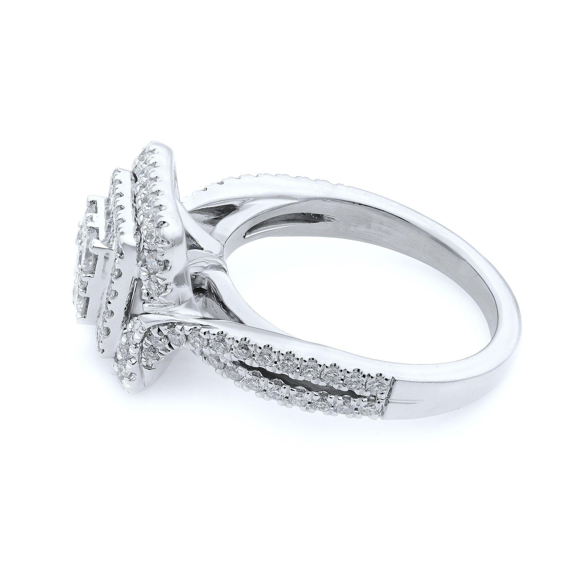Cette bague de fiançailles à double halo de diamants pavés est ornée de superbes diamants centraux et ronds de taille princesse. L'anneau est magnifiquement entouré d'un double halo constellé de diamants éblouissants et le motif de la tige fendue de