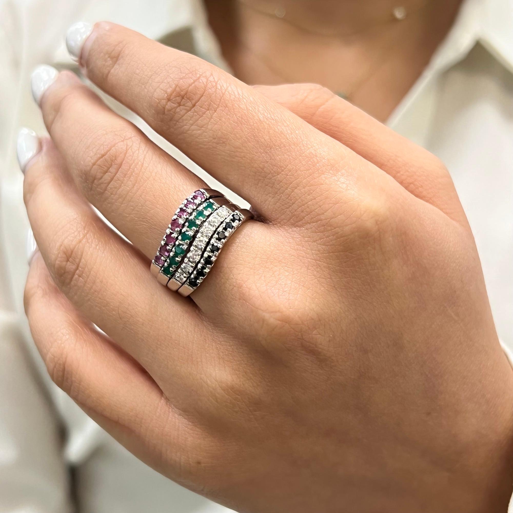 This stunning multi band ring comes with various forms of gem set bands held together. It features four bands encrusted with Ruby, Emerald, Diamond and Blue Sapphire. Each band width: 2.5mm. Ring size: 9. Total weight: 9.64. Great pre-owned