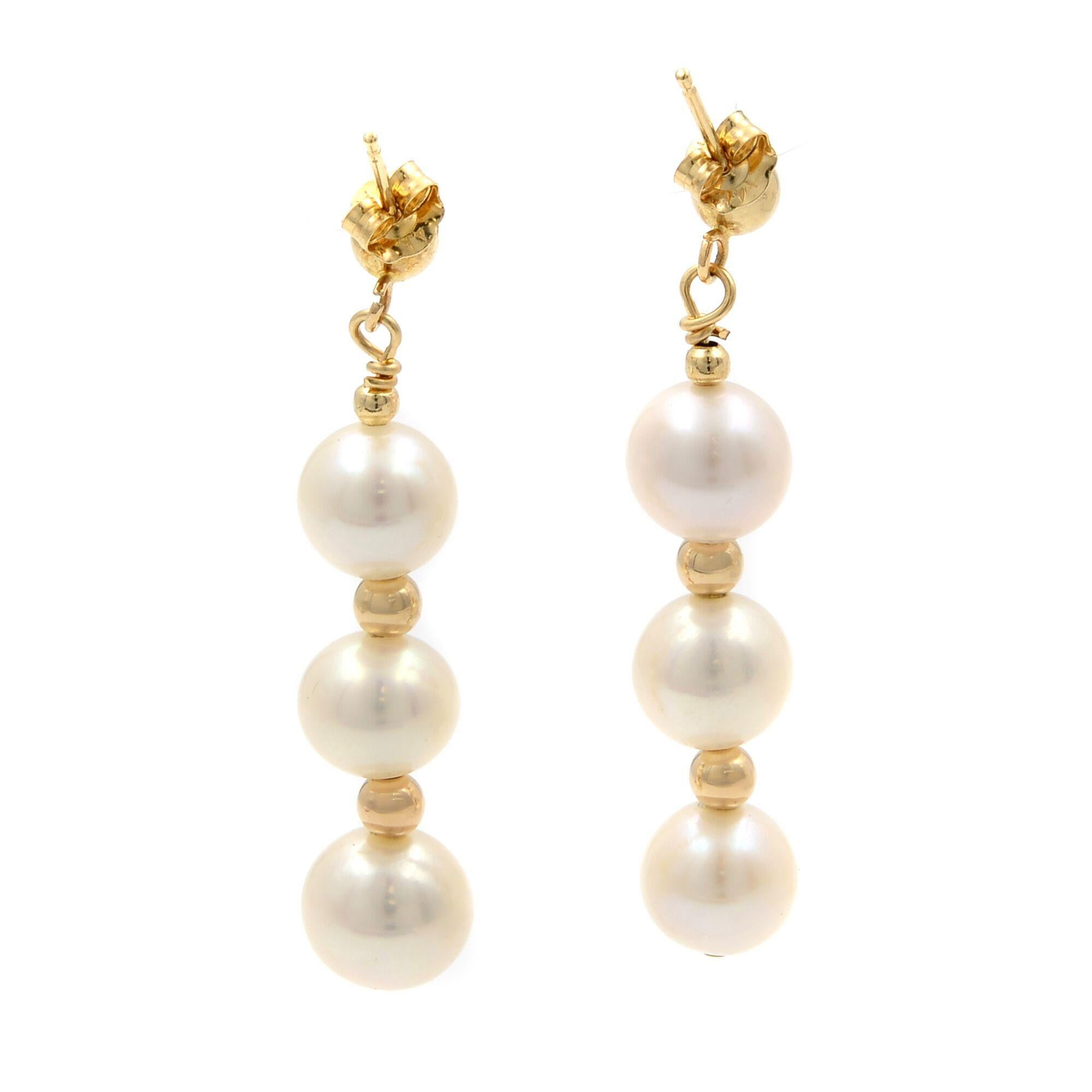 Beautiful freshwater white pearl drop earrings crafted in 14k yellow gold. Put on the perfect finishing touch with these all-natural cultured freshwater pearls earrings. 3 pearls on each earring. Each pearl measures 7mm, earring length is 35mm.