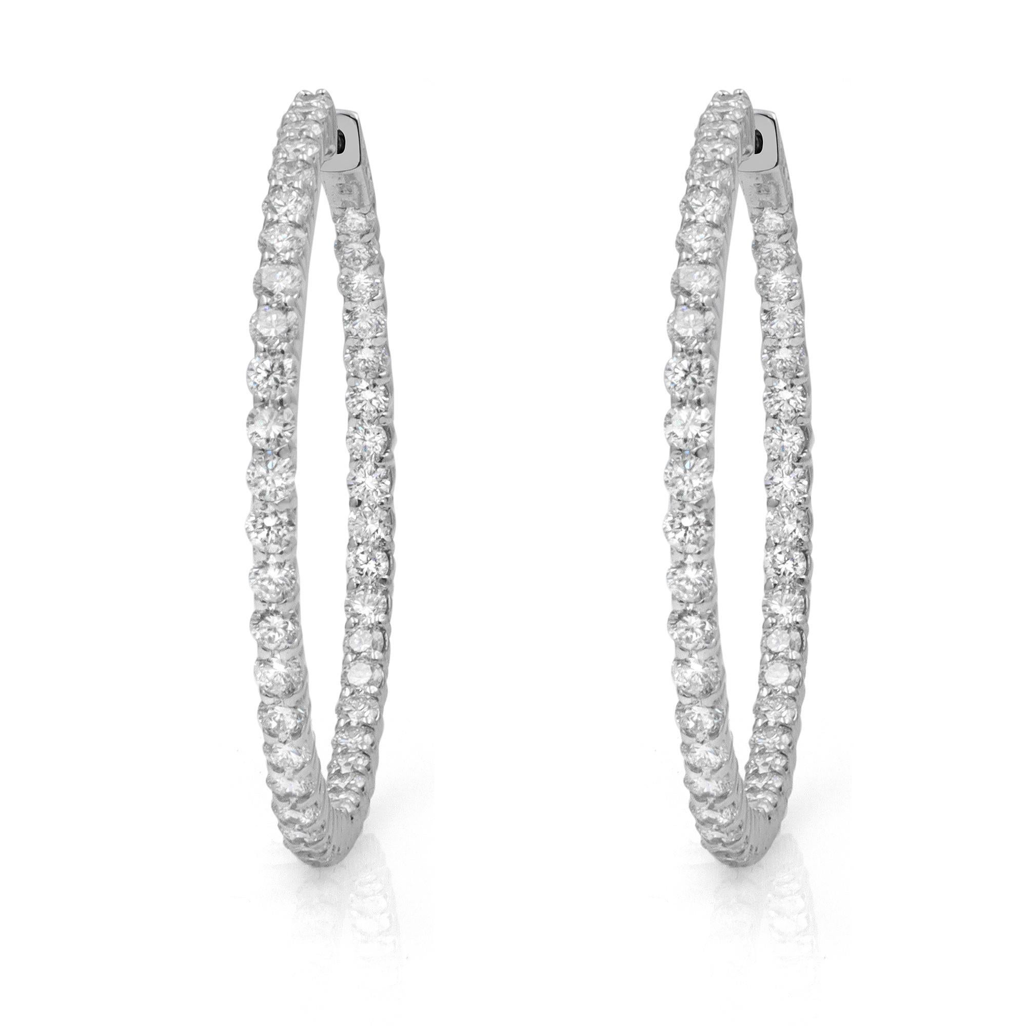 These stylish and elegant 14k white gold hoop earrings feature prong-set round diamonds in a single line. The diamonds embellish these earrings on the inside and the outside, offering a dazzling look from every angle. Total carat weight 5.61cttw.