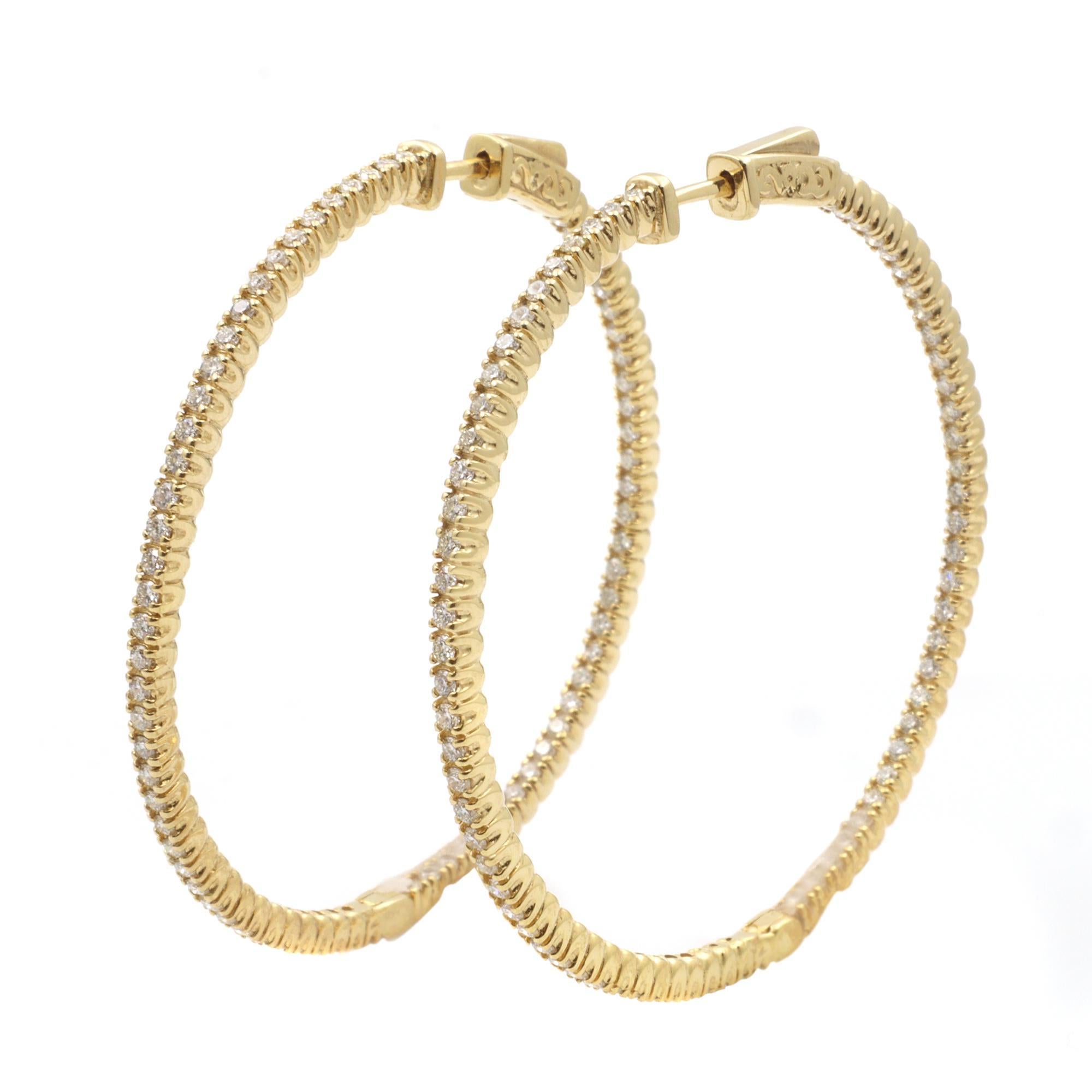 These stylish and elegant 14k yellow gold hoop earrings feature prong-set round diamonds in a single line. The diamonds embellish these earrings on the inside and the outside, offering a dazzling look from every angle. Total carat weight 1.75cttw.