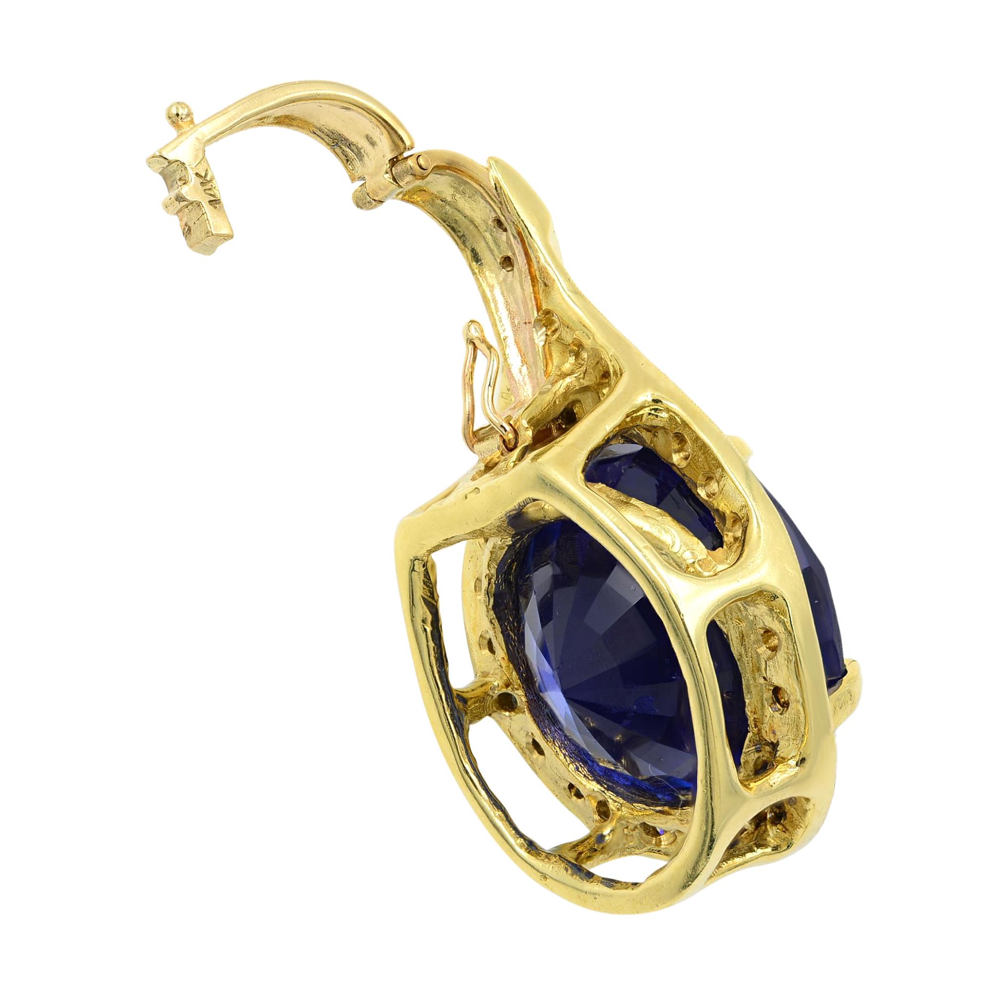 This knockout jewel astounds your senses with an extra-radiant, deep, rich blue color, oval cut Tanzanite - weighing 27.66 carats. The uniquely stunning and vibrant gemstone is surrounded by brilliant-cut diamonds set in 14k yellow gold. This