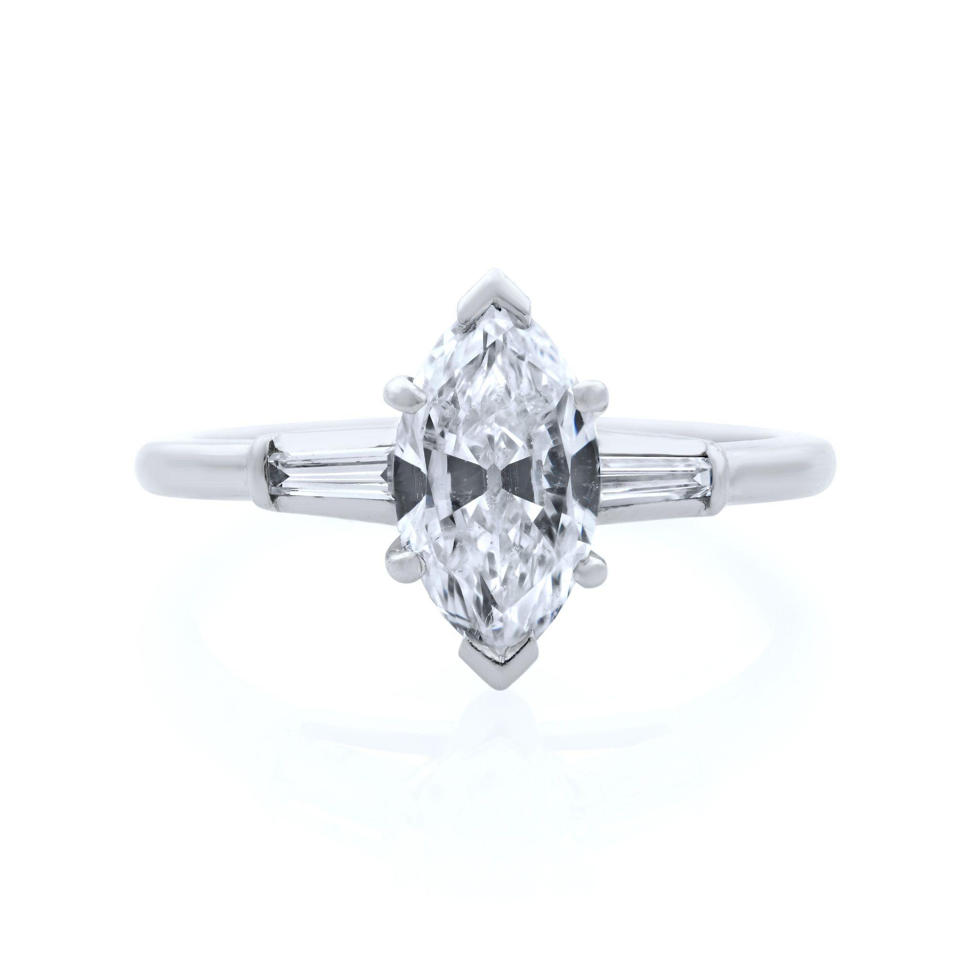 This engagement ring features a marquise cut diamond in the center with a tiny baguette cut diamonds on each side. Center stone 1.00 carat. Diamond color G and SI1 clarity. Ring size 6 (can be sized). This ring comes in our jewelry presentation box.