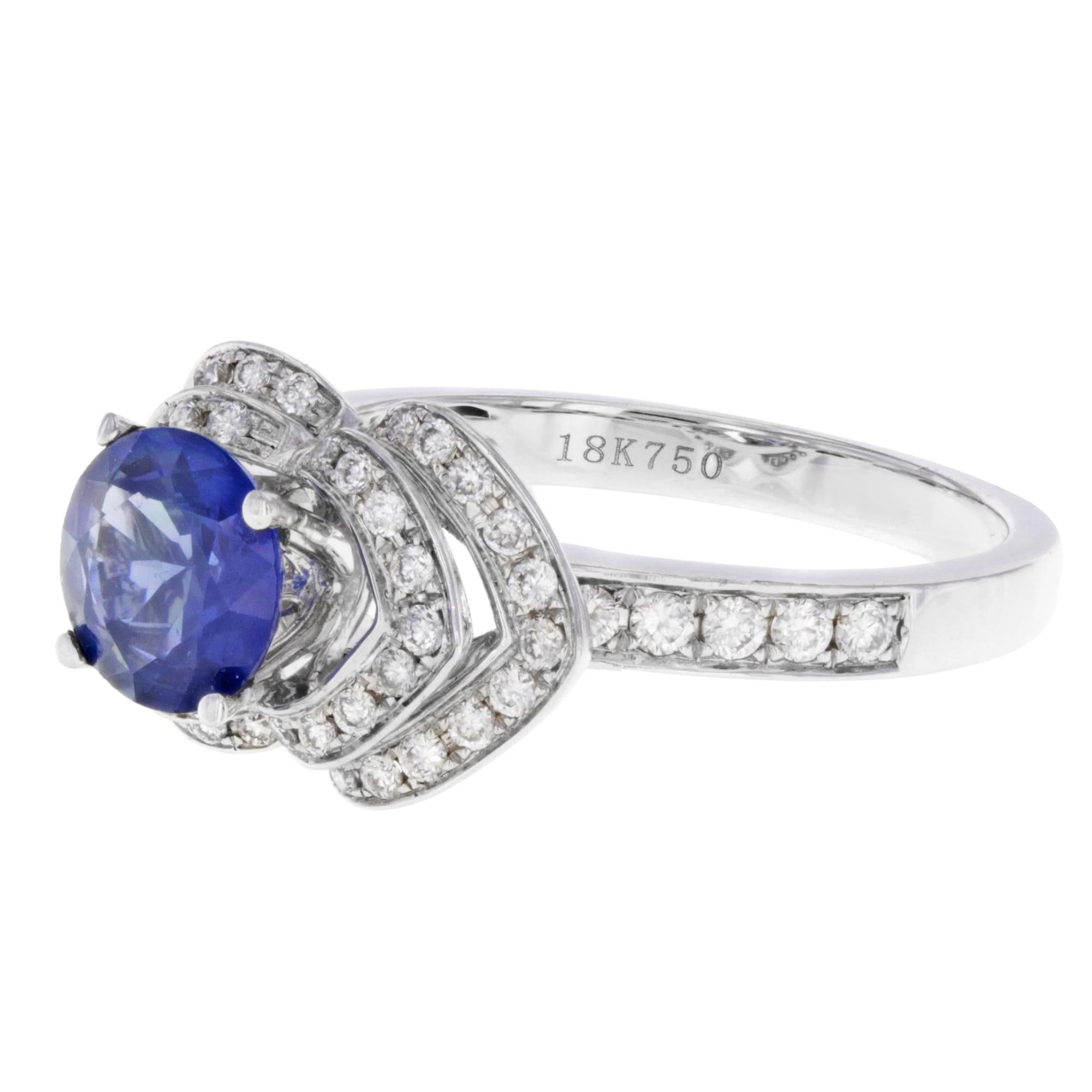 Absolutely beautiful ladies diamond & sapphire ring. The sapphire has a strong intense shade of bright blue, that exhibits great brilliance and wonderful sparkle adorned with 1.15 cttw prong set diamonds. The ring is crafted in 18k white gold. Ring