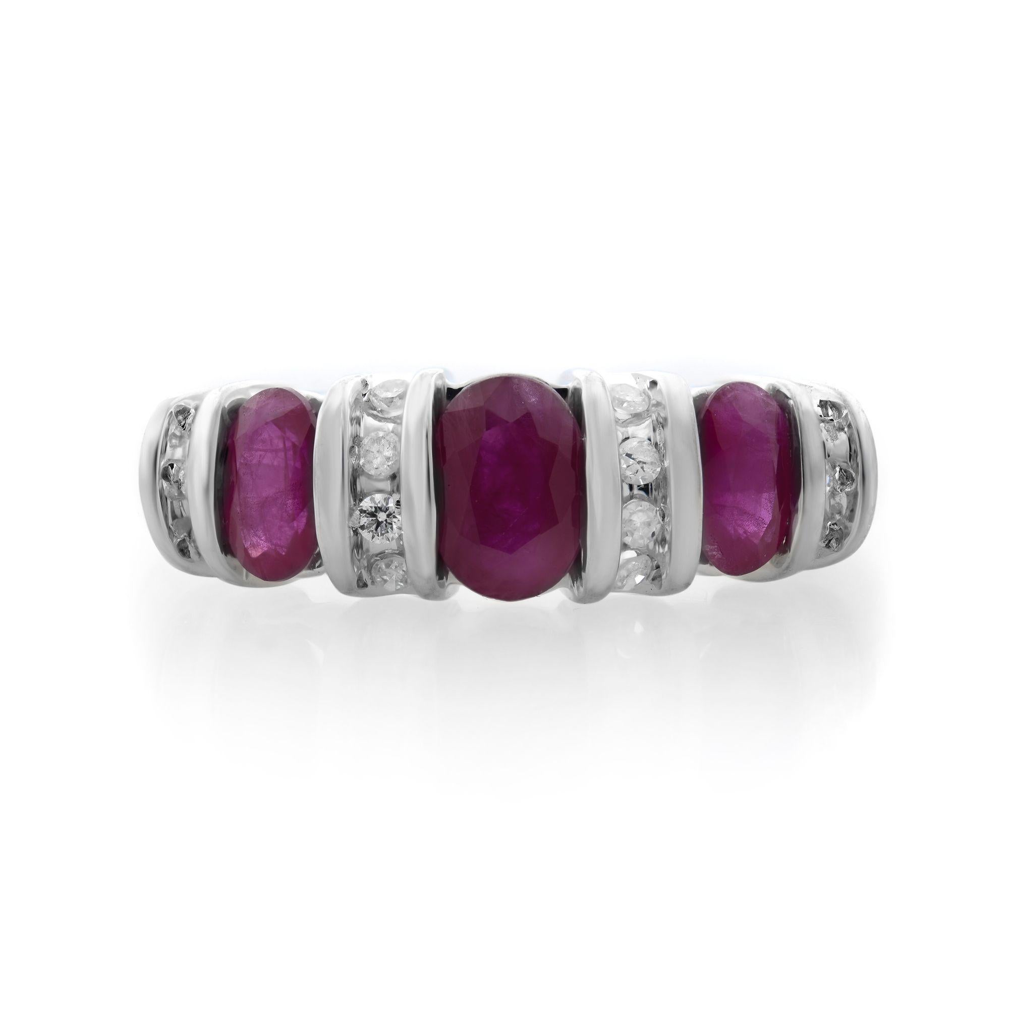 Este brillante anillo de aniversario de rubí y diamante está fabricado en oro blanco de 14 quilates. Presenta tres tallas ovaladas de 0,75 quilates en total. Rubíes engastados en canal combinados con diminutos diamantes engastados en canal de 0,17