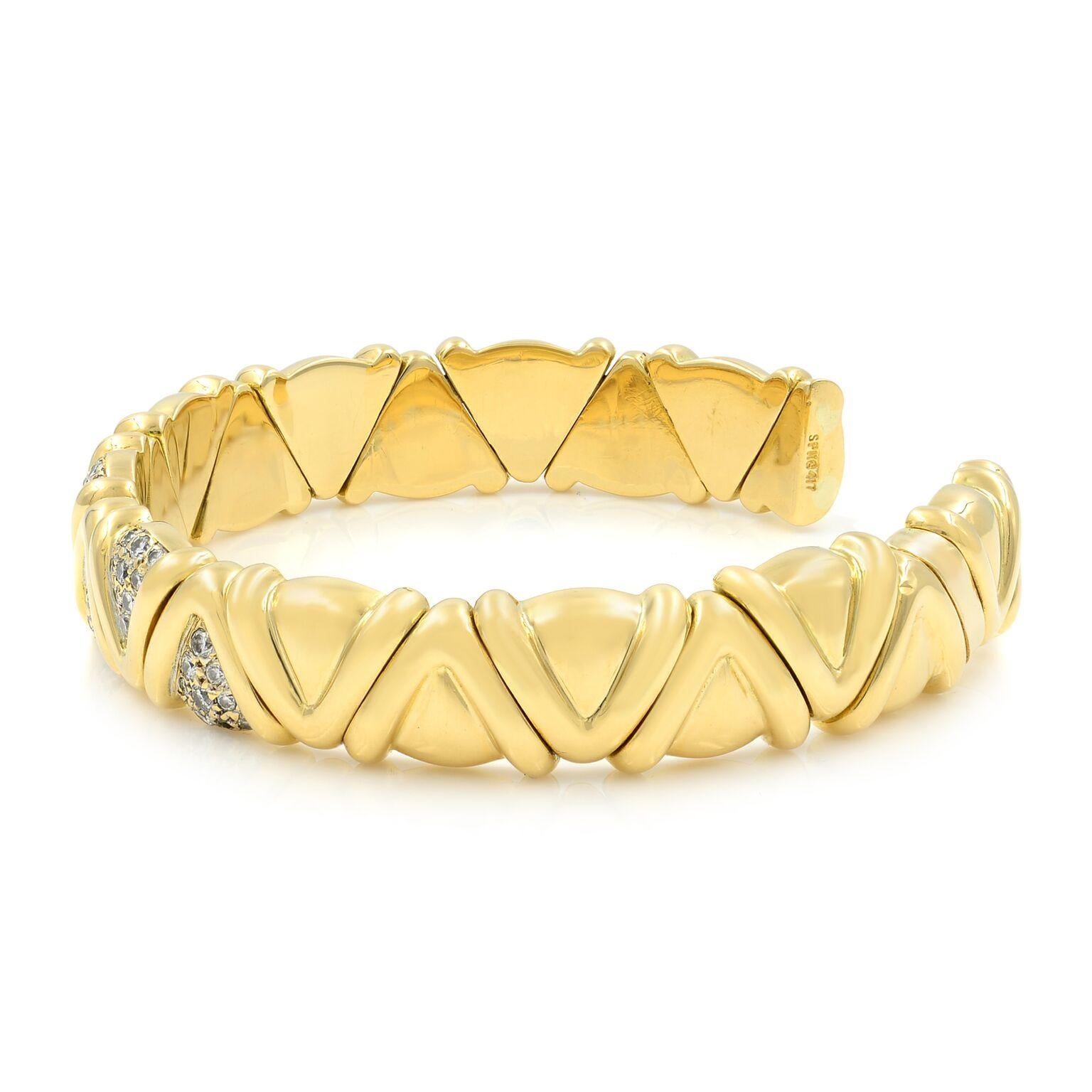 A fashionable Estate cuff bracelet crafted in solid 18k yellow gold. This bracelet features a geometric fitted design at the front of the band with micro pave set round brilliant cut diamonds. The total diamond weight is 1.00cts. Bracelet width: