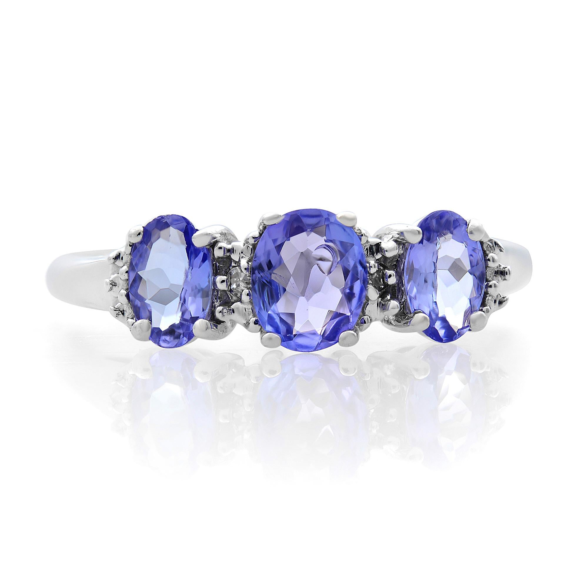 Charm your leading lady with this vibrant gemstone ring. Crafted in 14K white gold, this lovely look showcases a 5.0 x 4.0mm oval-shaped violet-purple tanzanite at the center, flanked by a duo of 4.7 x 3.0mm tanzanites. A pair of shimmering diamond