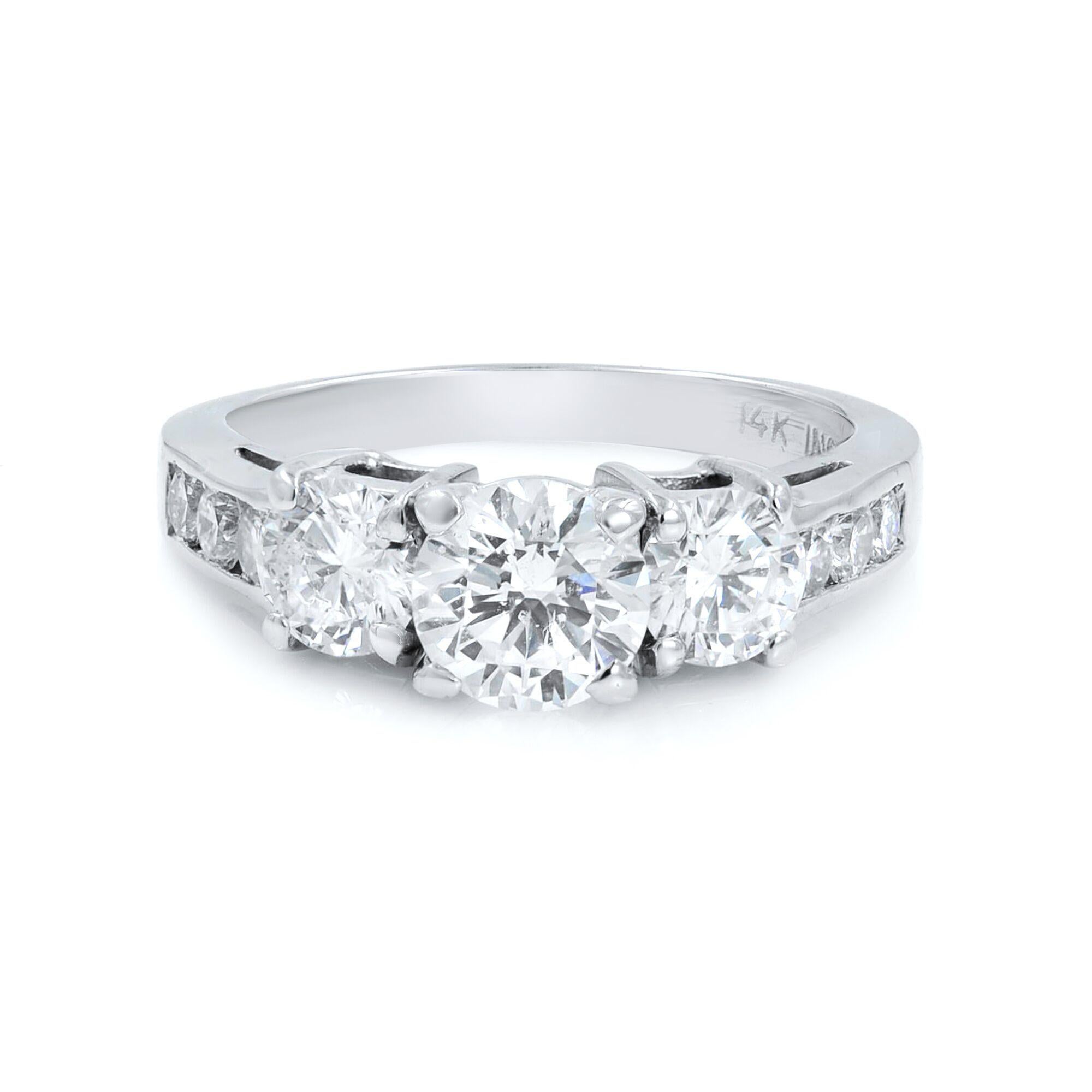 This beautiful ring features 3 round cut diamonds. The center diamond weighs 0.70 ctts with G-H color and VS-SI clarity and side diamonds: (2) 0.60 ctts similar to the center diamond, shank diamonds: (6) 0.18 cttw. The metal is 14k white gold. It