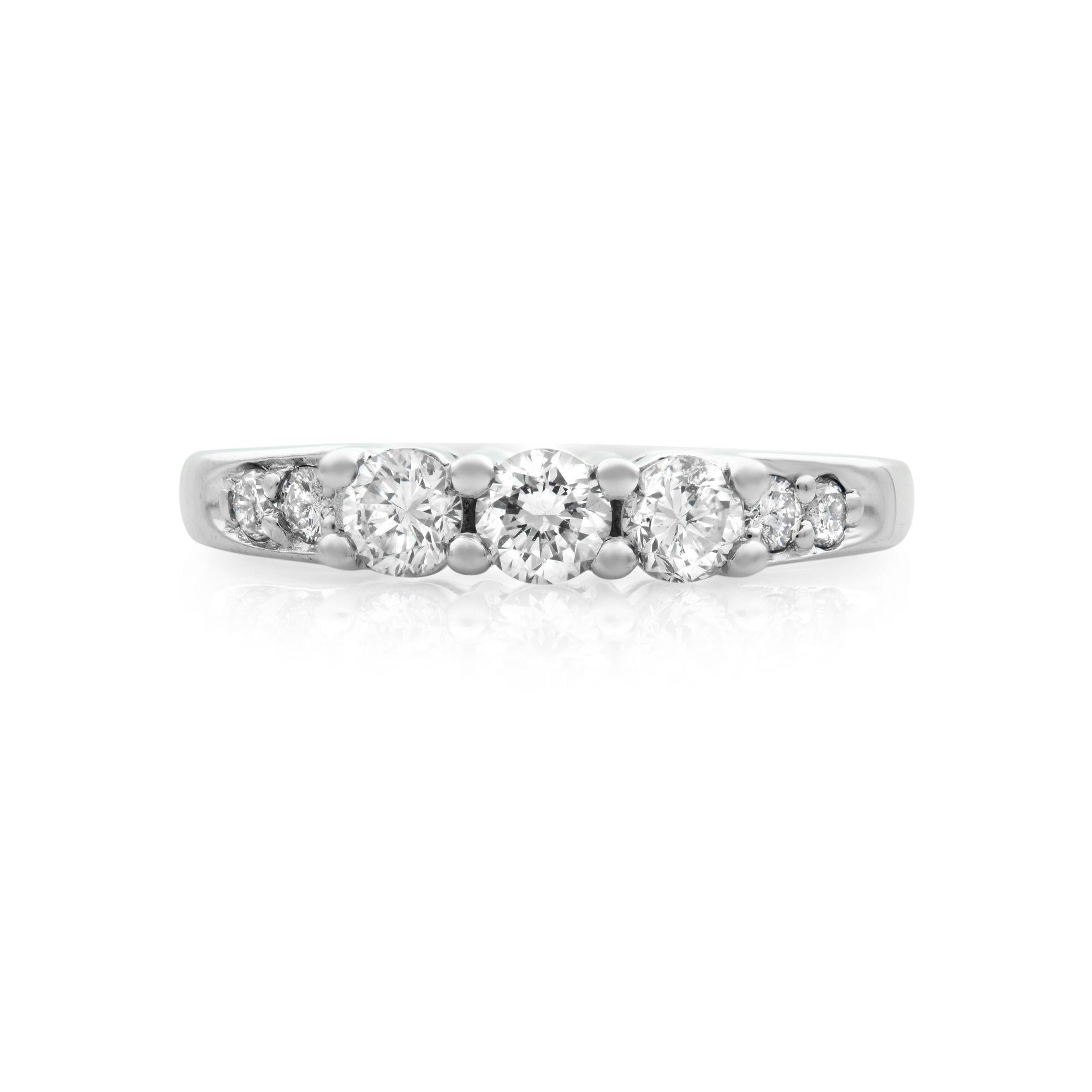 This classically beautiful design features three sparkling round cut diamond stones with additional prong set diamond accents to adorn the 14k white gold band. Total carat weight 0.55 carat. Diamond clarity SI1 and color G. The ring weighs 3.5 grams