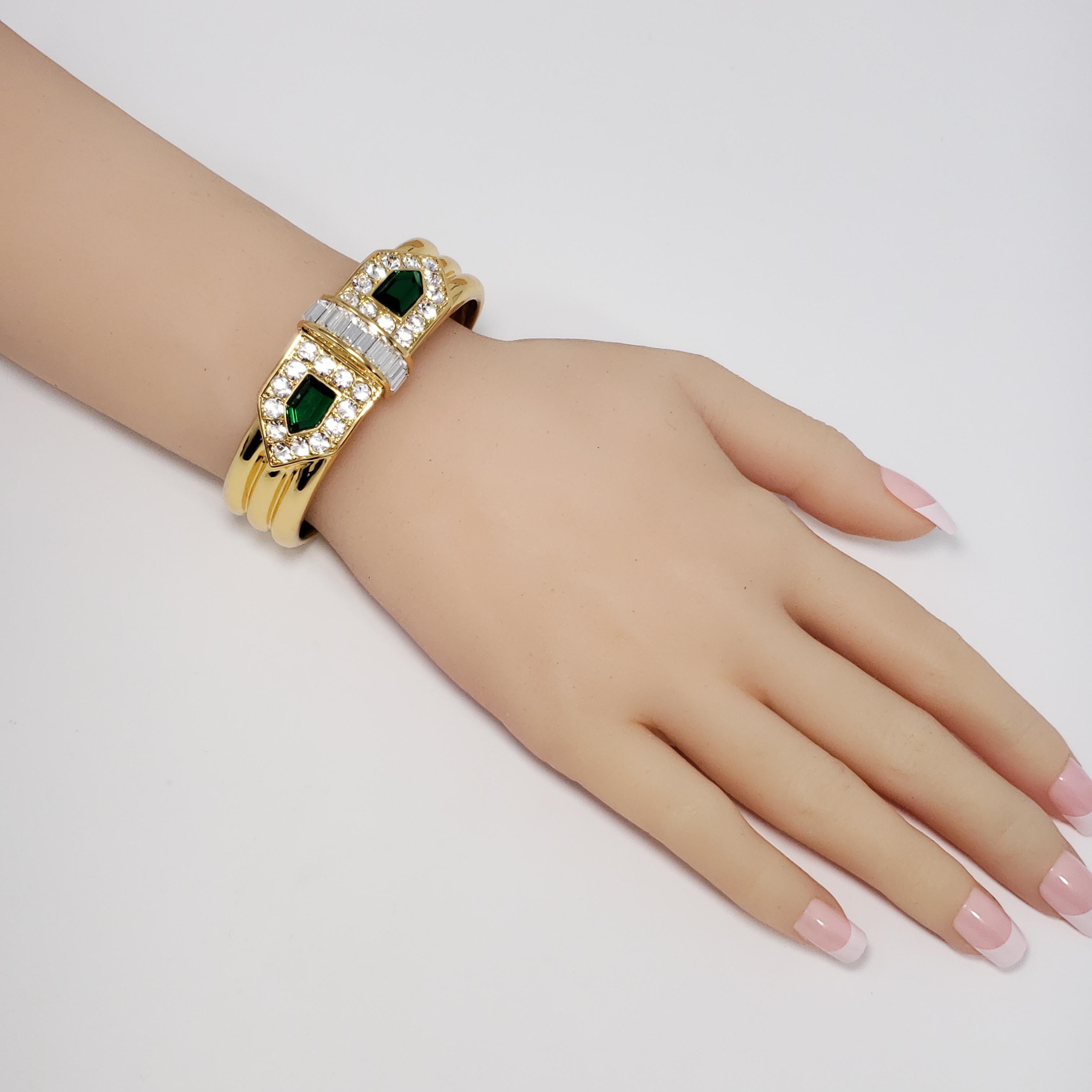 Clear and emerald Swarovski crystals meet at the center of this '20s-inspired 22K yellow gold plated cuff bracelet by Rachel Zoe.

Inner diameter at widest part: 2.25 in / 5.75 cm
