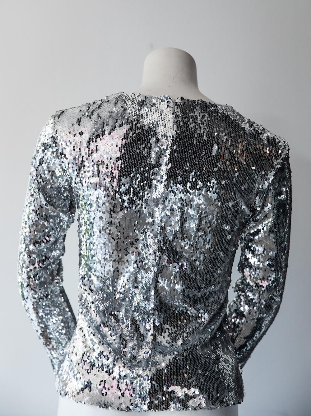 Racil long sleeve blouse with all-over silver iridescent sequins. New Year's Eve or wear to an evening event. Wear with pants or a skirt! New with original tags attached. Fitted, crew-neck silhouette with back zip closure. 

Size XS