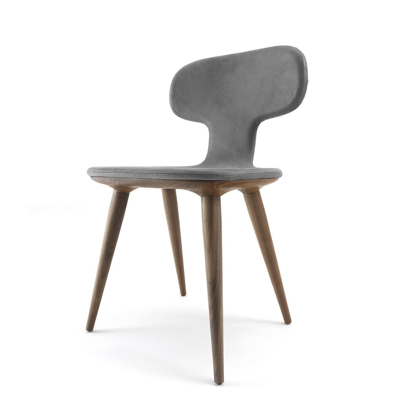 Dining chair racing with grey genuine leather 
made with sinuous and enveloping forms, visible stitching, 
with solid walnut wood shaped structure. Wood treated with
natural wax of vegetable origin with pine extracts finish. 
Also available with