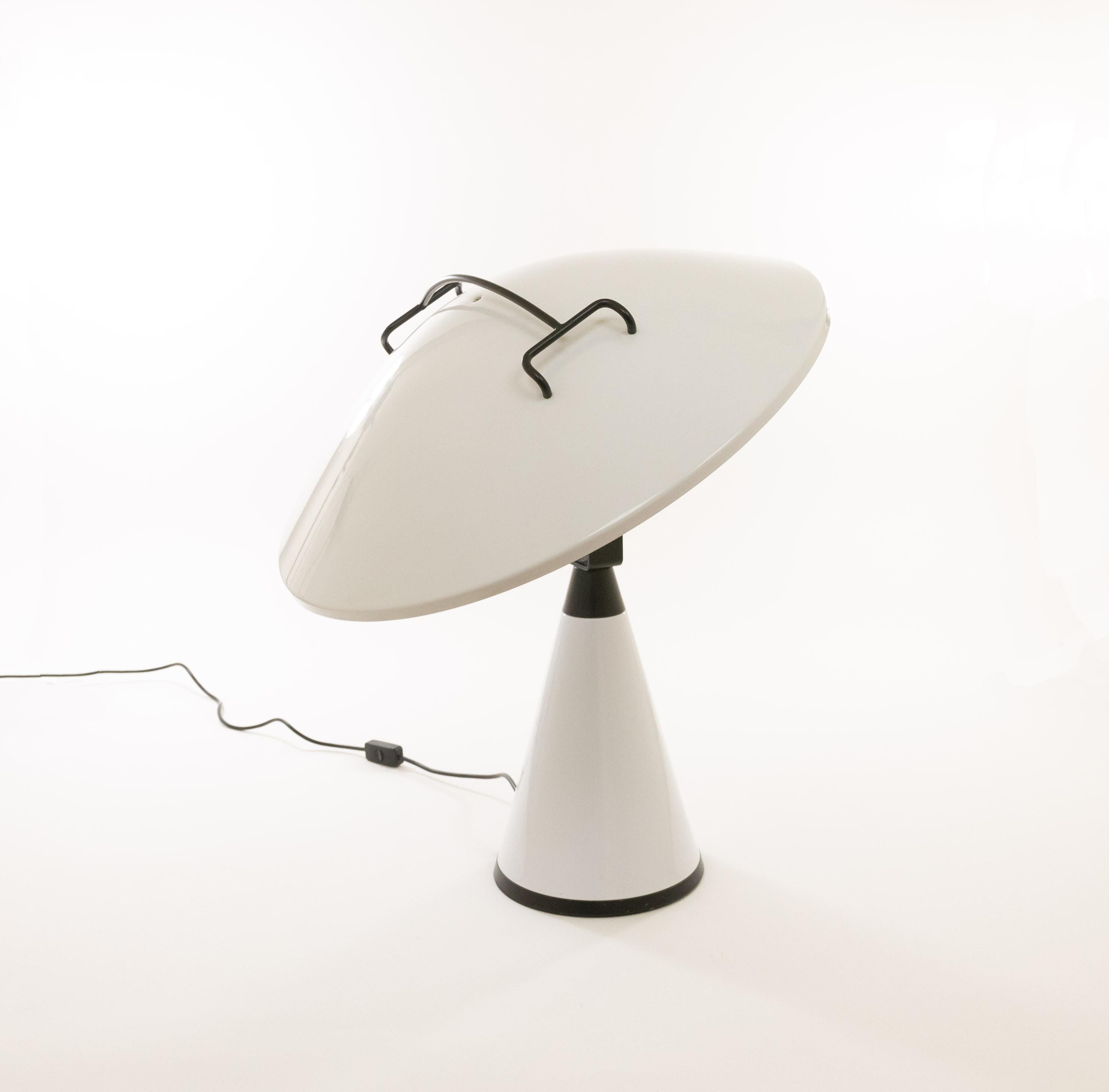 Impressive model 676 Radar table or floor lamp designed by Elio Martinelli and manufactured by Martinelli Luce.

The Radar lamp consists of a cone-shaped base and a large white metal shade with a black handle on top. A special feature of the lamp