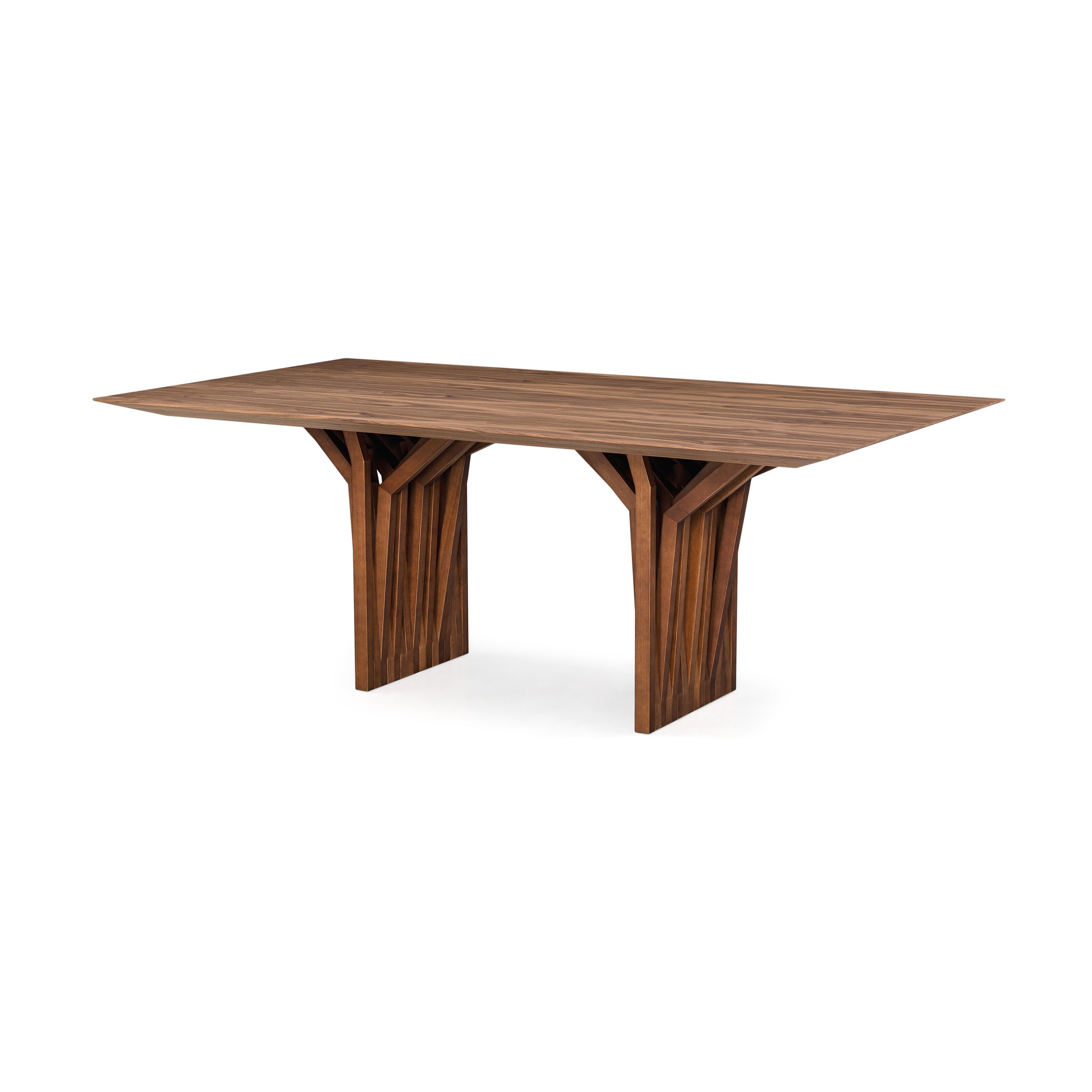 The Radi dining table by Uultis presents a striking blend of contemporary design and natural inspiration. Crafted with a refined walnut finish wood veneer top with dovetail joints, the table rests on a distinctive base whose branching silhouette